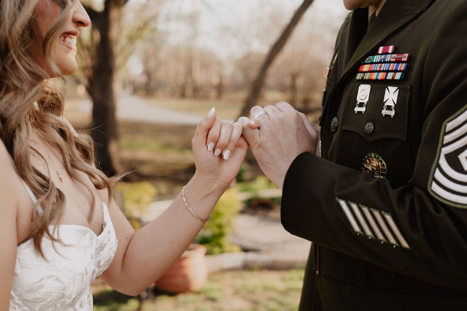 Military service member and bride share intimate moments during their wedding ceremony outdoors.