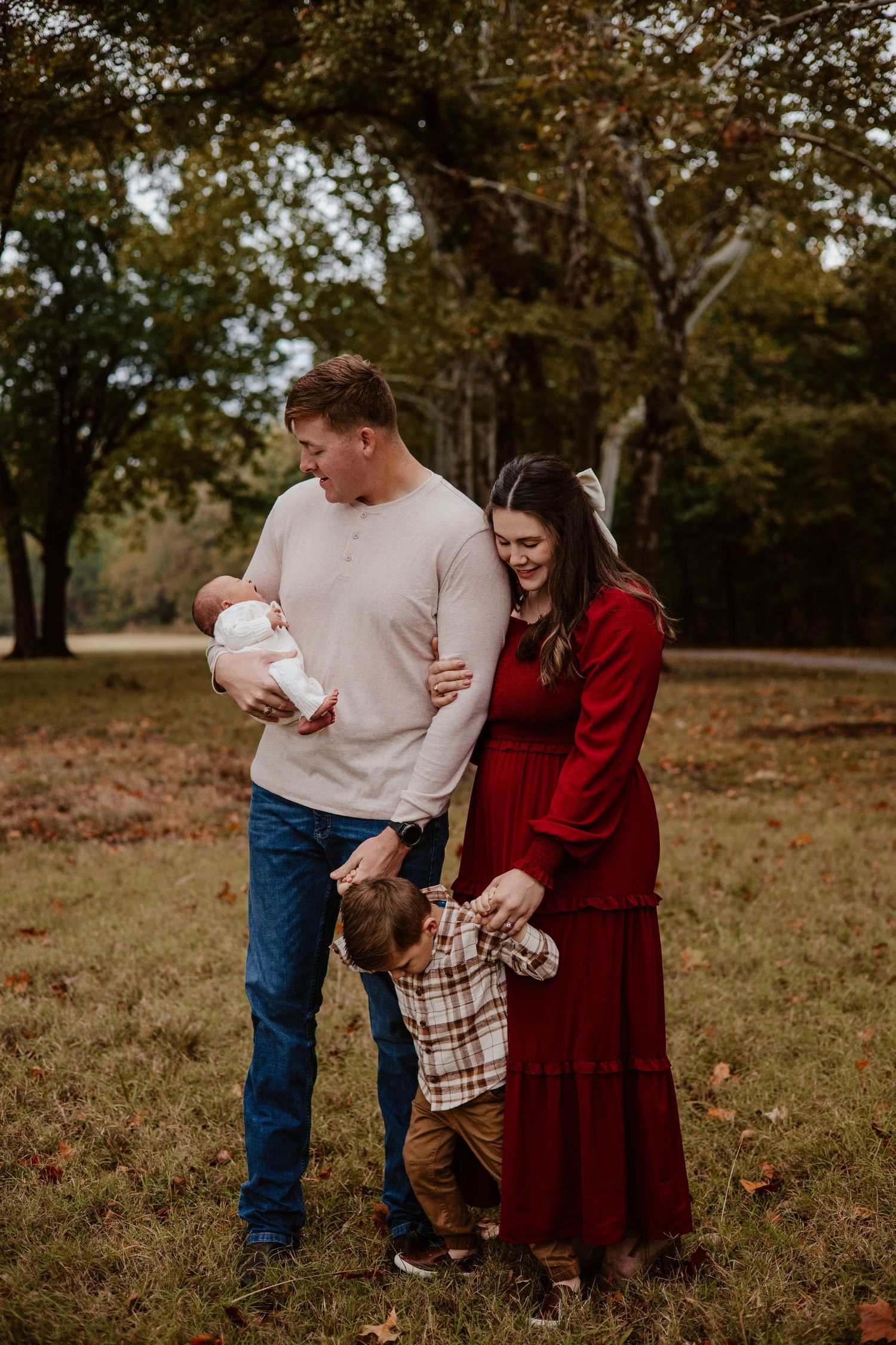 Family sharing intimate moment together in rustic outdoor setting during fall.