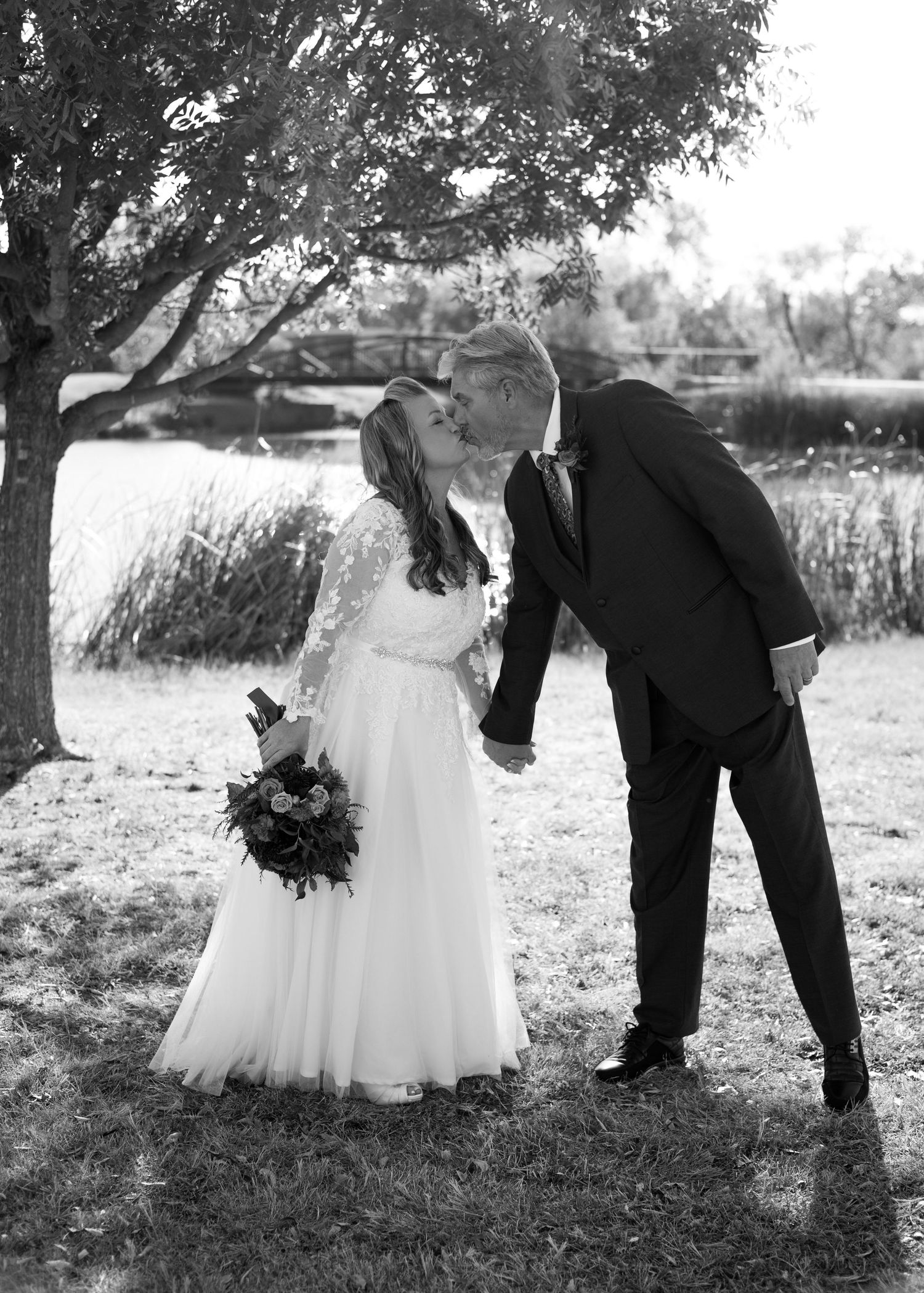 Black and white wedding photos showing playful moments between a couple in an outdoor setting.