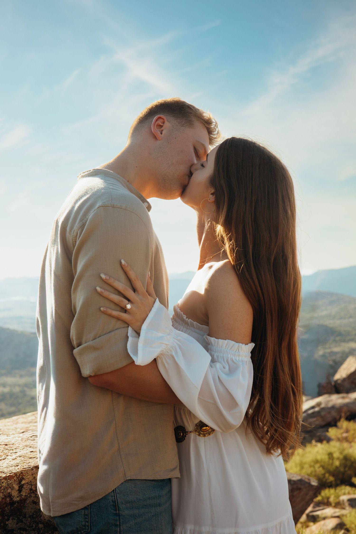 Romantic couple sharing an intimate moment against a scenic mountain backdrop.