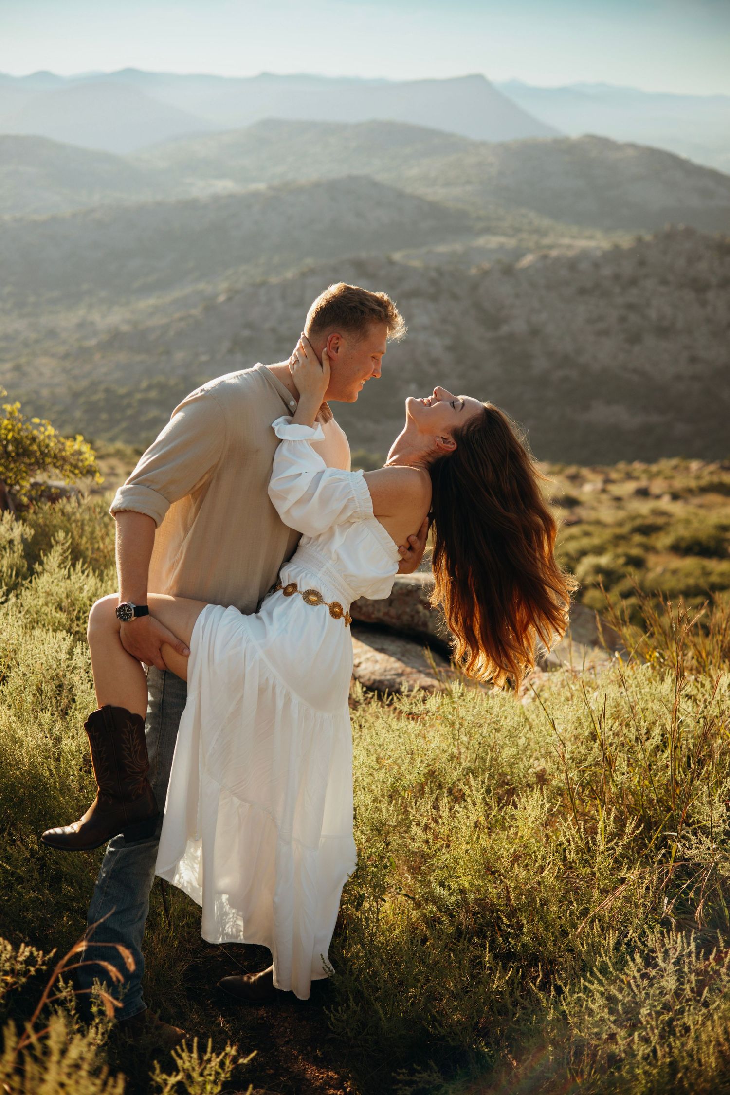 A romantic dip pose against a scenic mountain landscape at golden hour.