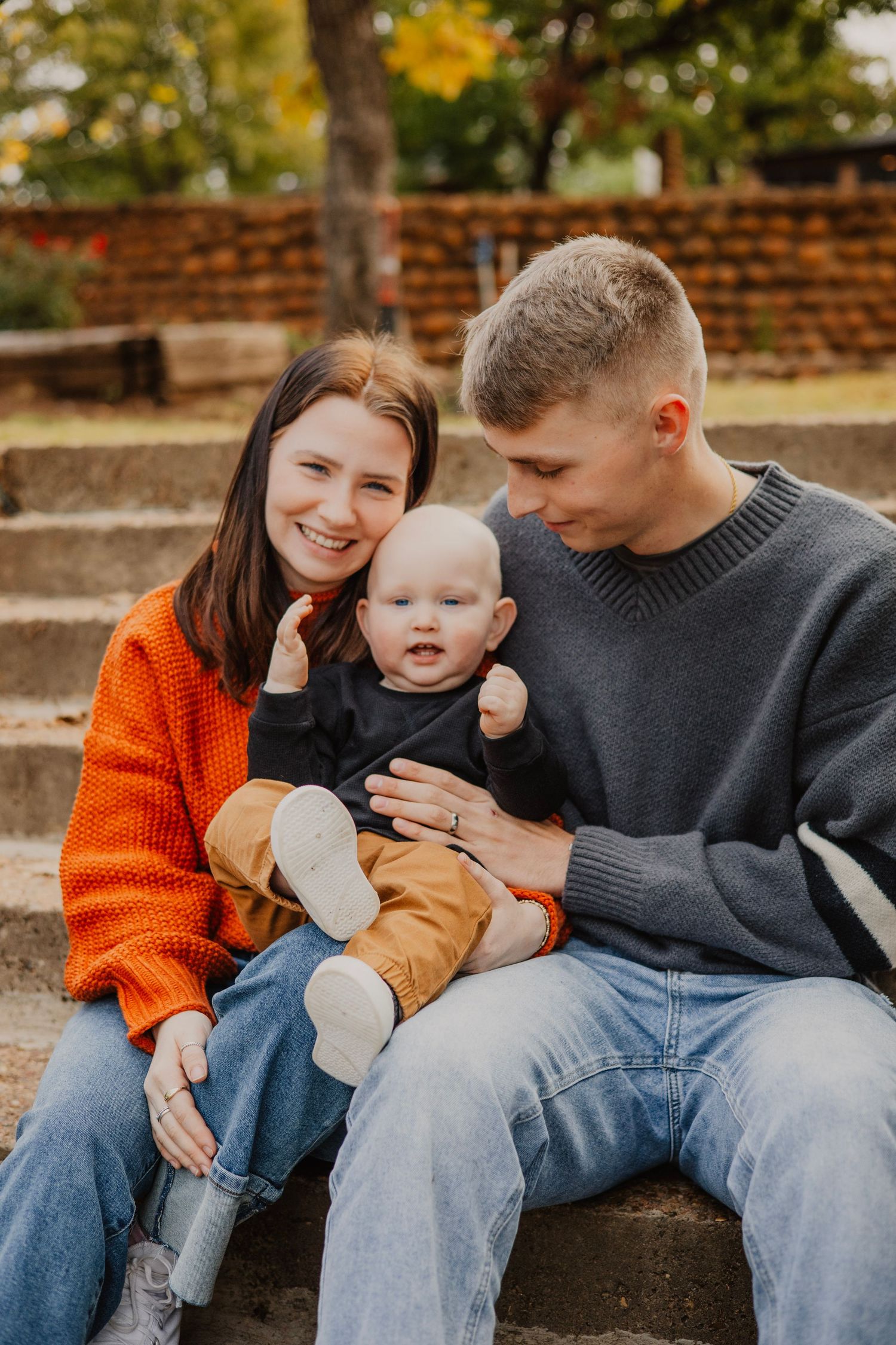Candid family moments on stone steps showing playful interactions in casual fall attire.