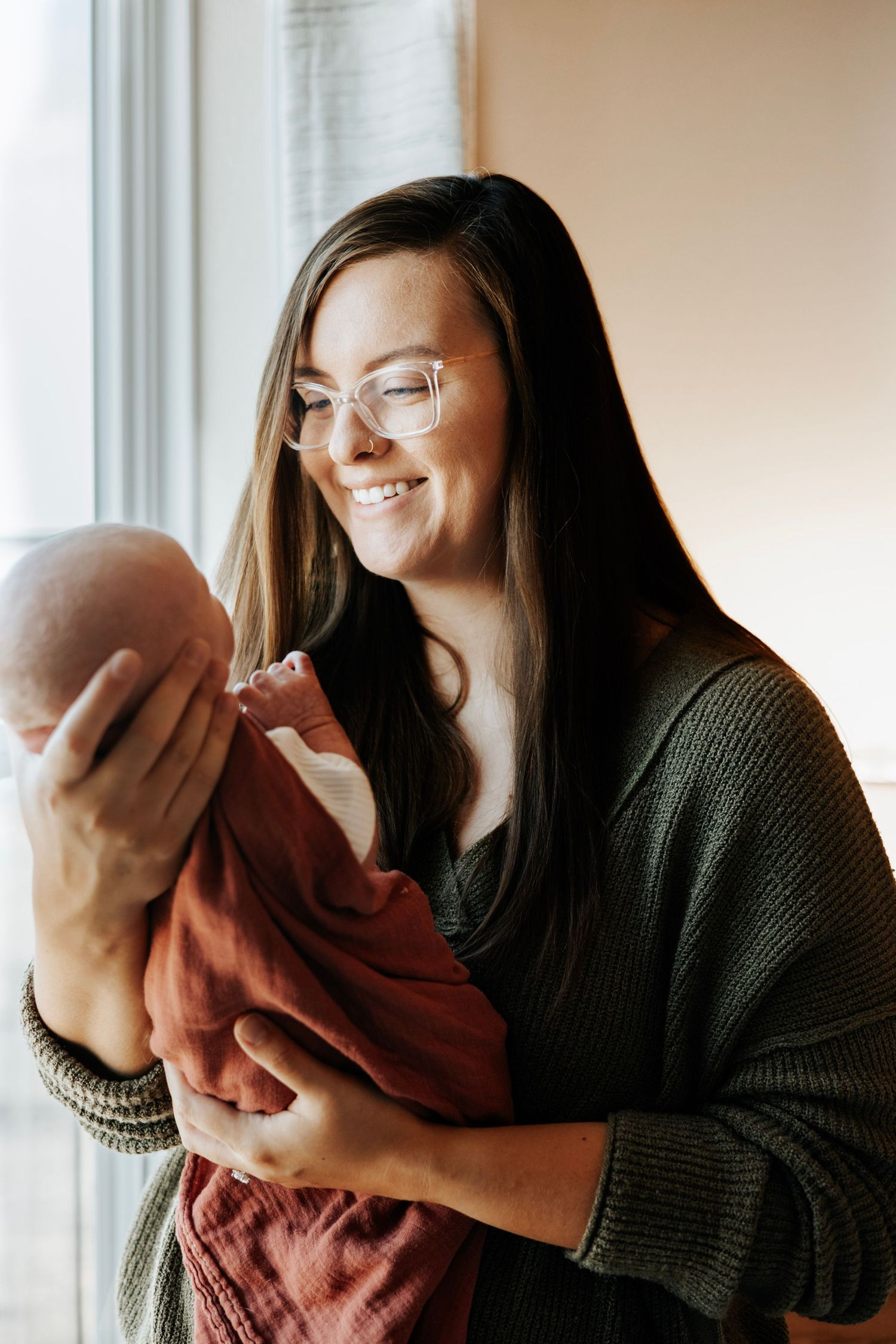 Tender moment by window with soft natural light streaming in.