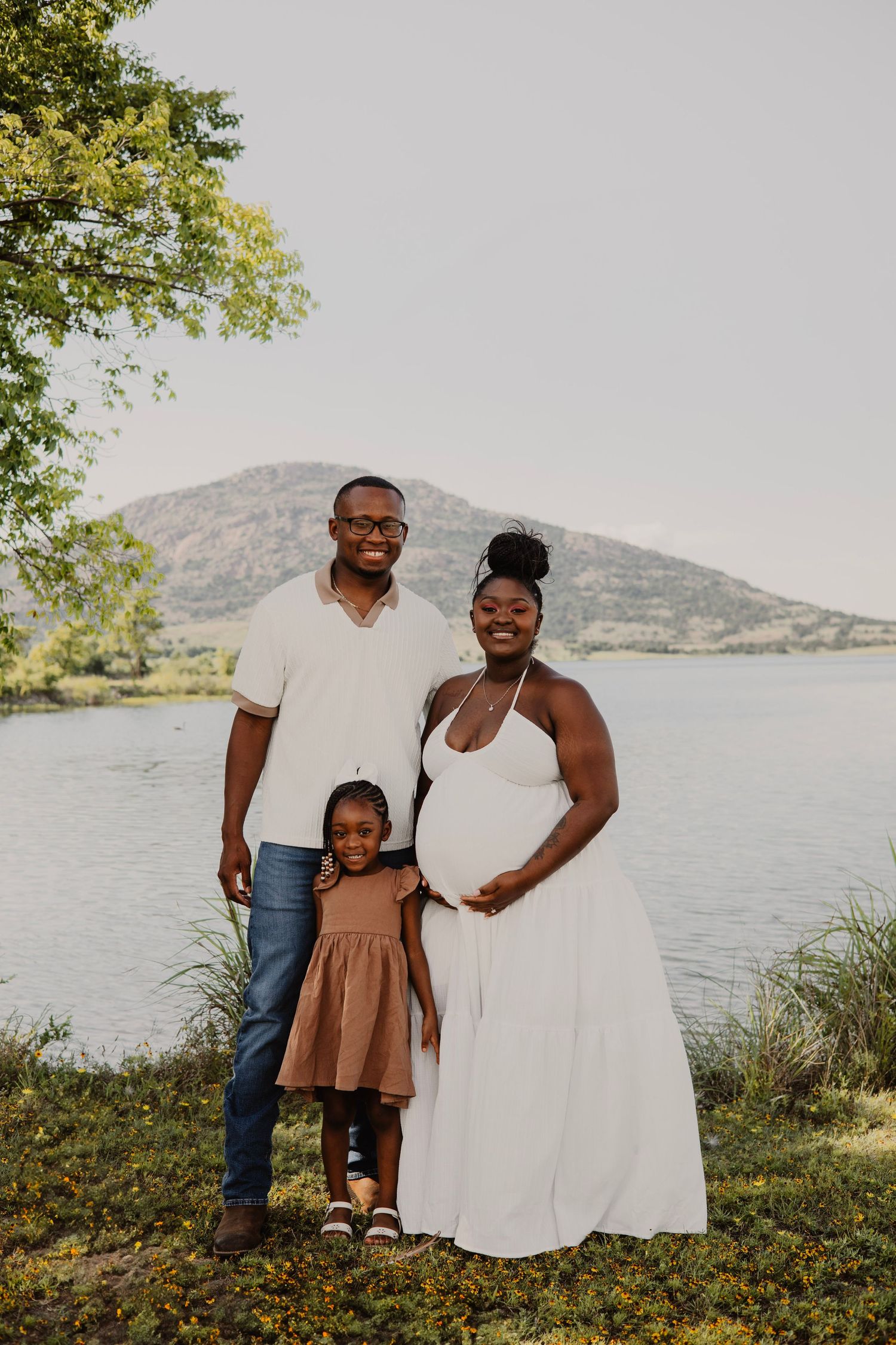 Family maternity photo with mountains and lake in background.
