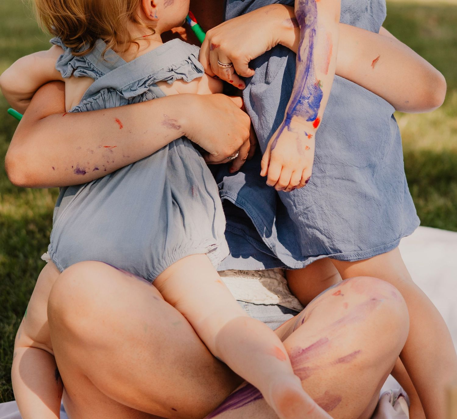 A series of images showing someone in a light blue dress sitting on grass during a sunny outdoor photo session.