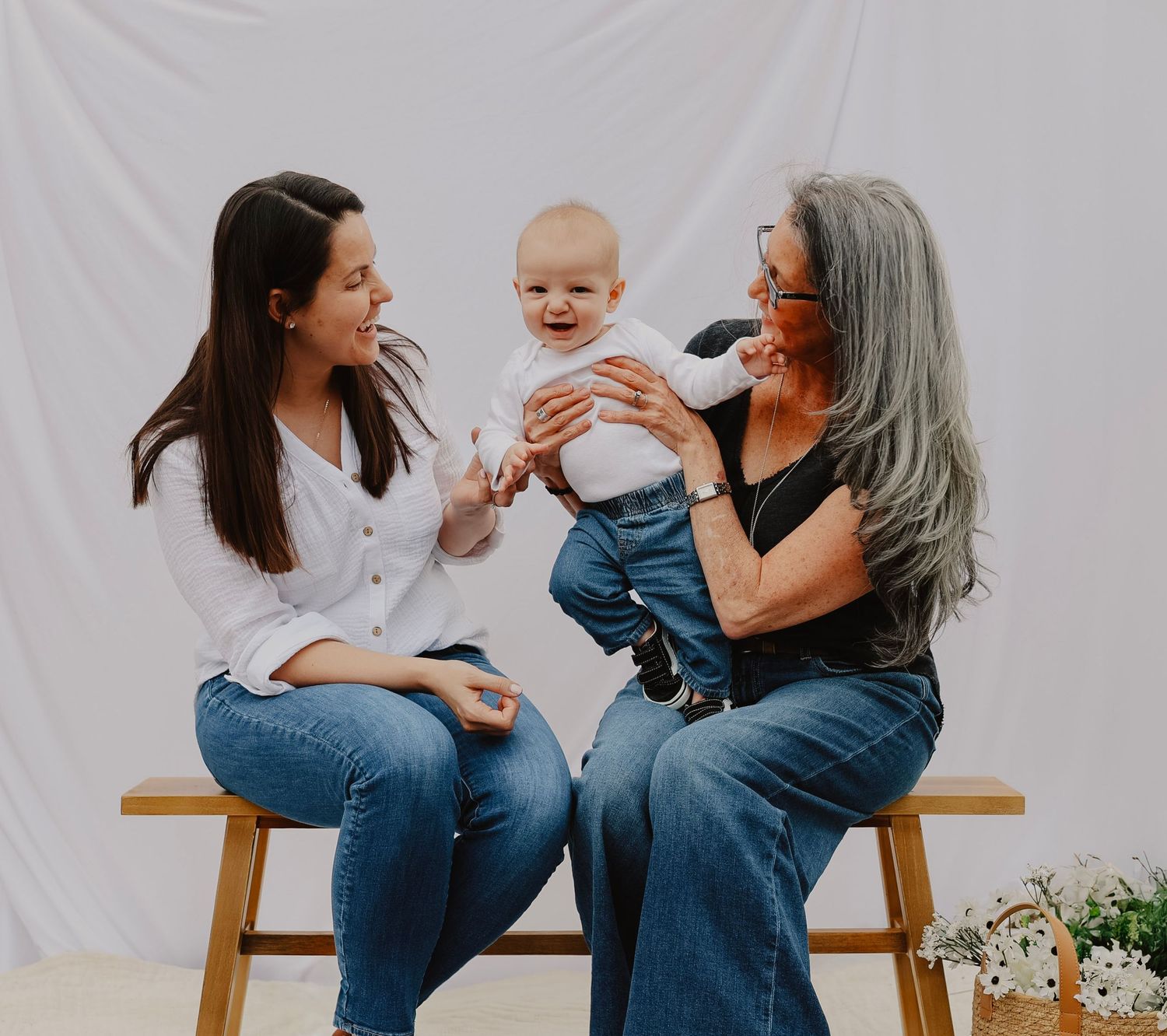 Casual studio portraits of family members interacting on wooden bench.