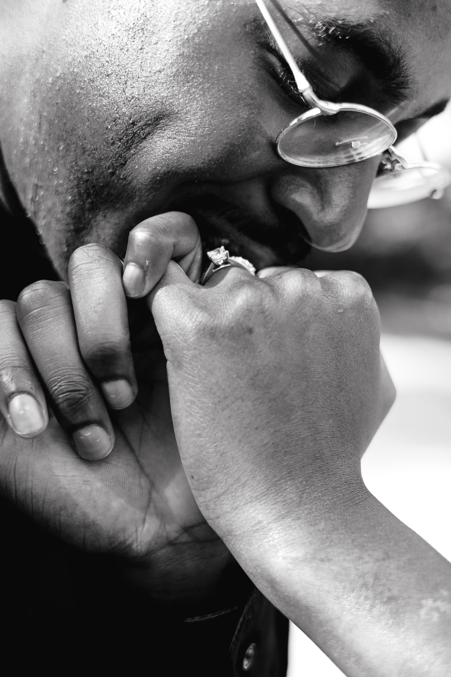Close-up black and white photo of a romantic moment with a ring.