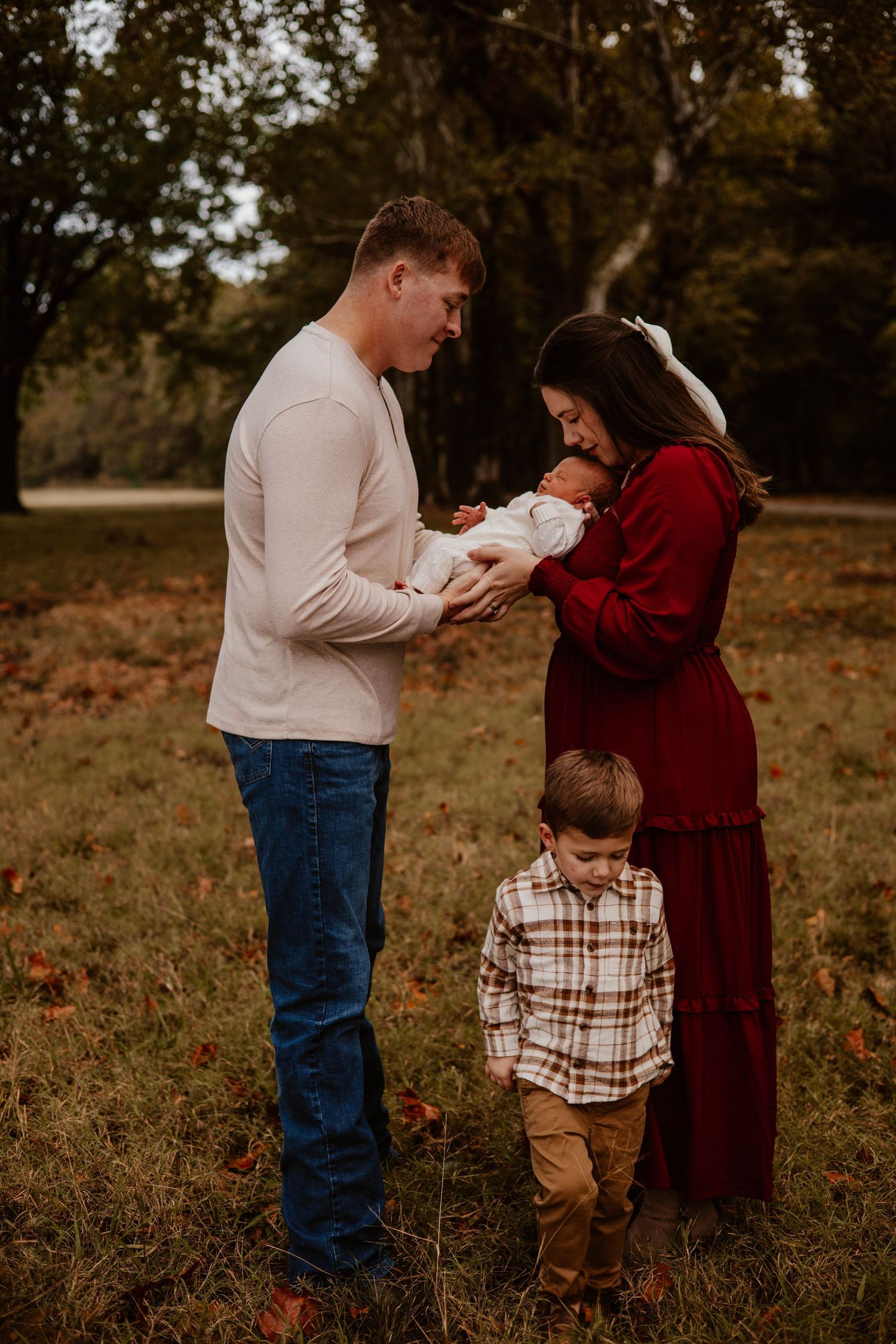 Family enjoying autumn day together in field with fallen leaves.