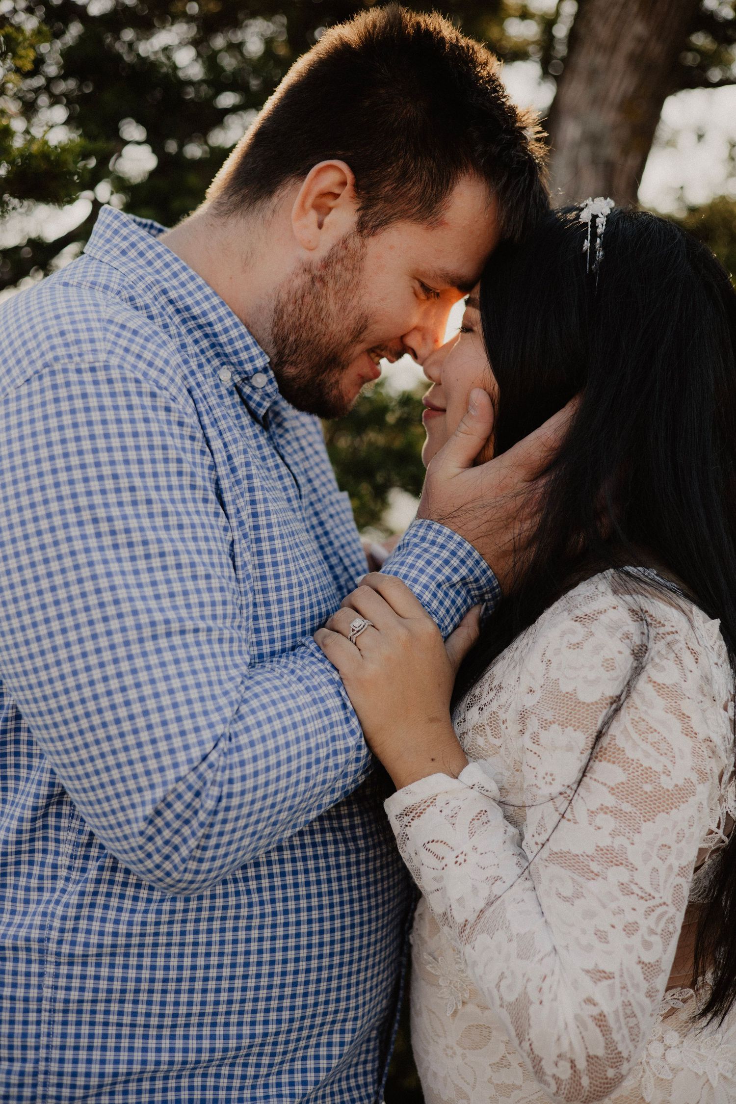 An intimate close-up of a couple sharing a tender moment outdoors.