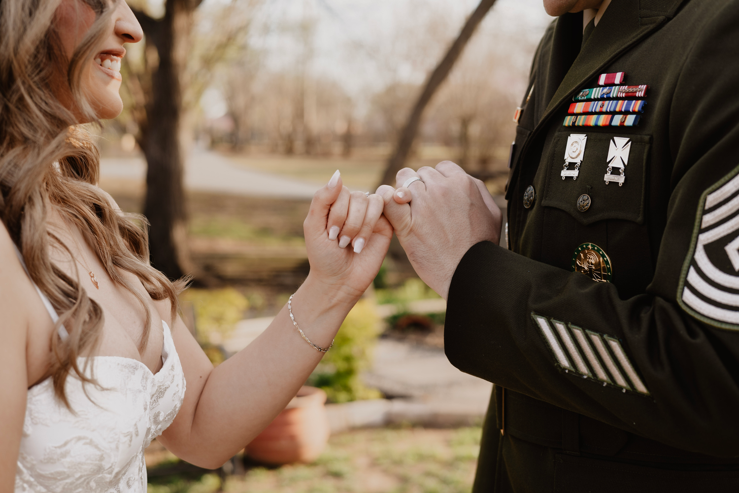 Military service member and bride holding hands during wedding ceremony. Captured by Kathleen Tolbert Photography