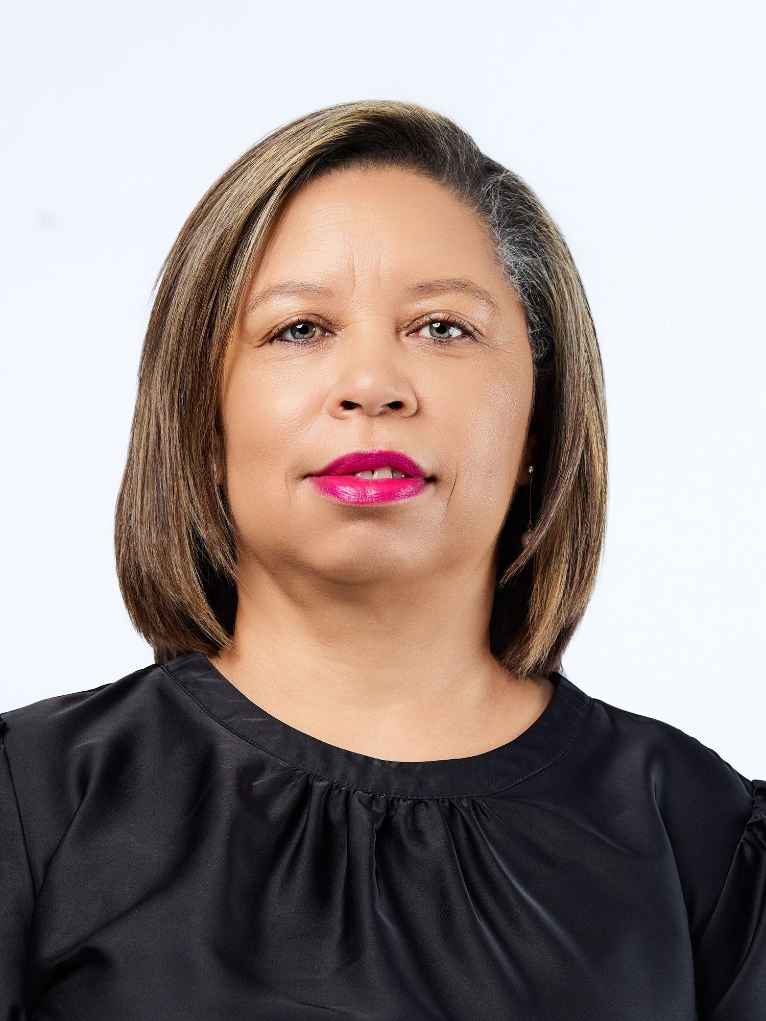 Professional headshot of a woman with highlighted bob hair wearing a black top with pink lipstick.
