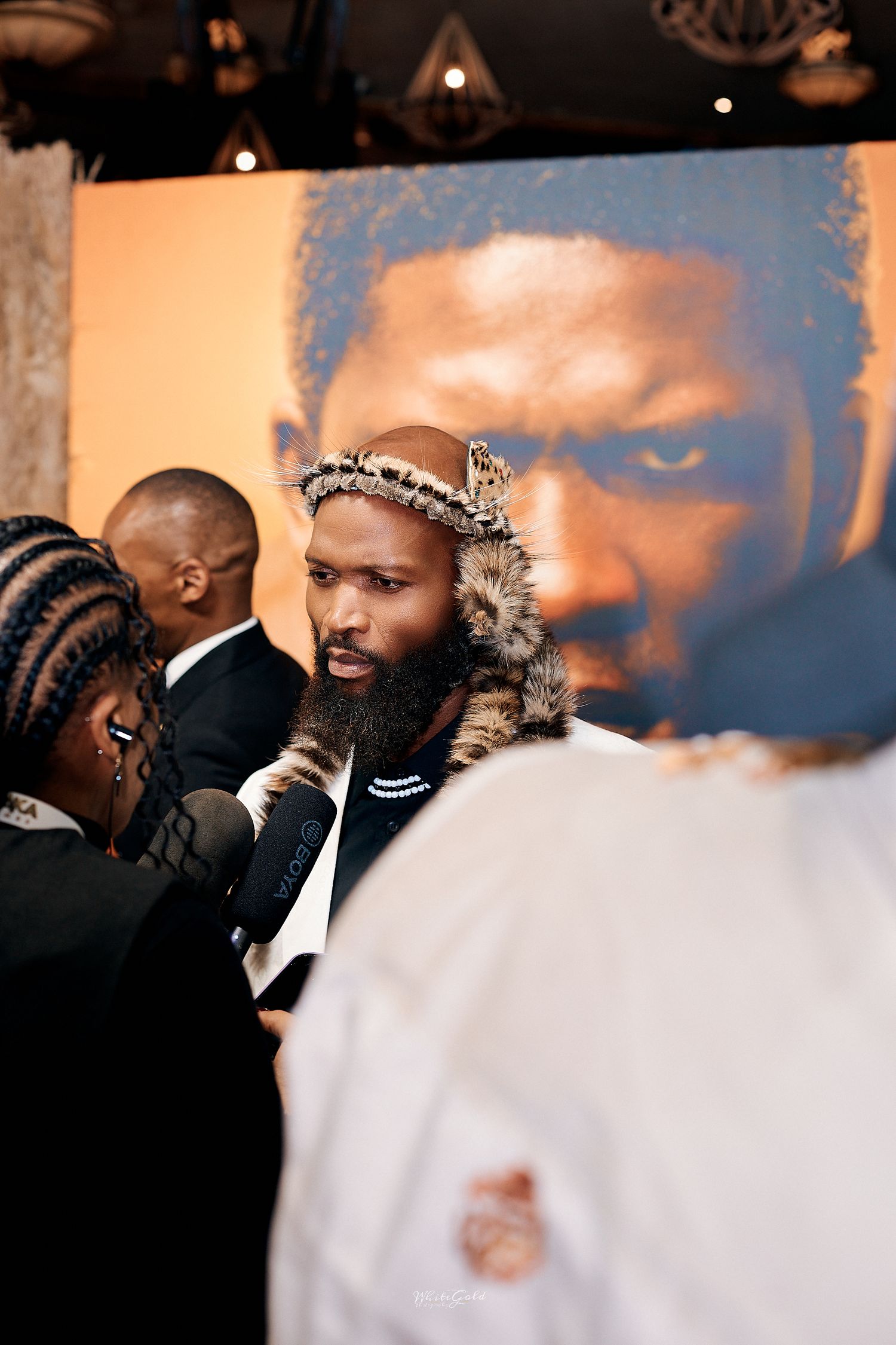 Man in traditional Zulu leopard skin attire at Shaka Ilembe premiere event.