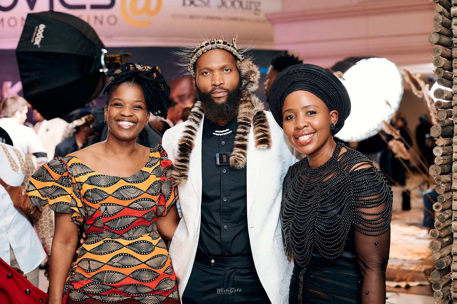 Three guests pose together at Shaka Ilembe TV series premiere red carpet.