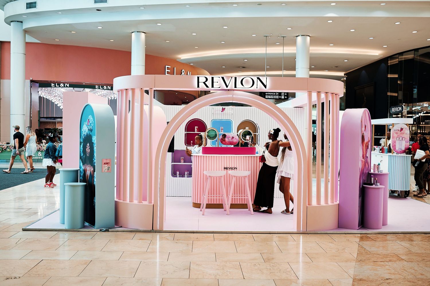 Revlon branded pop-up display booth inside a shopping mall.
