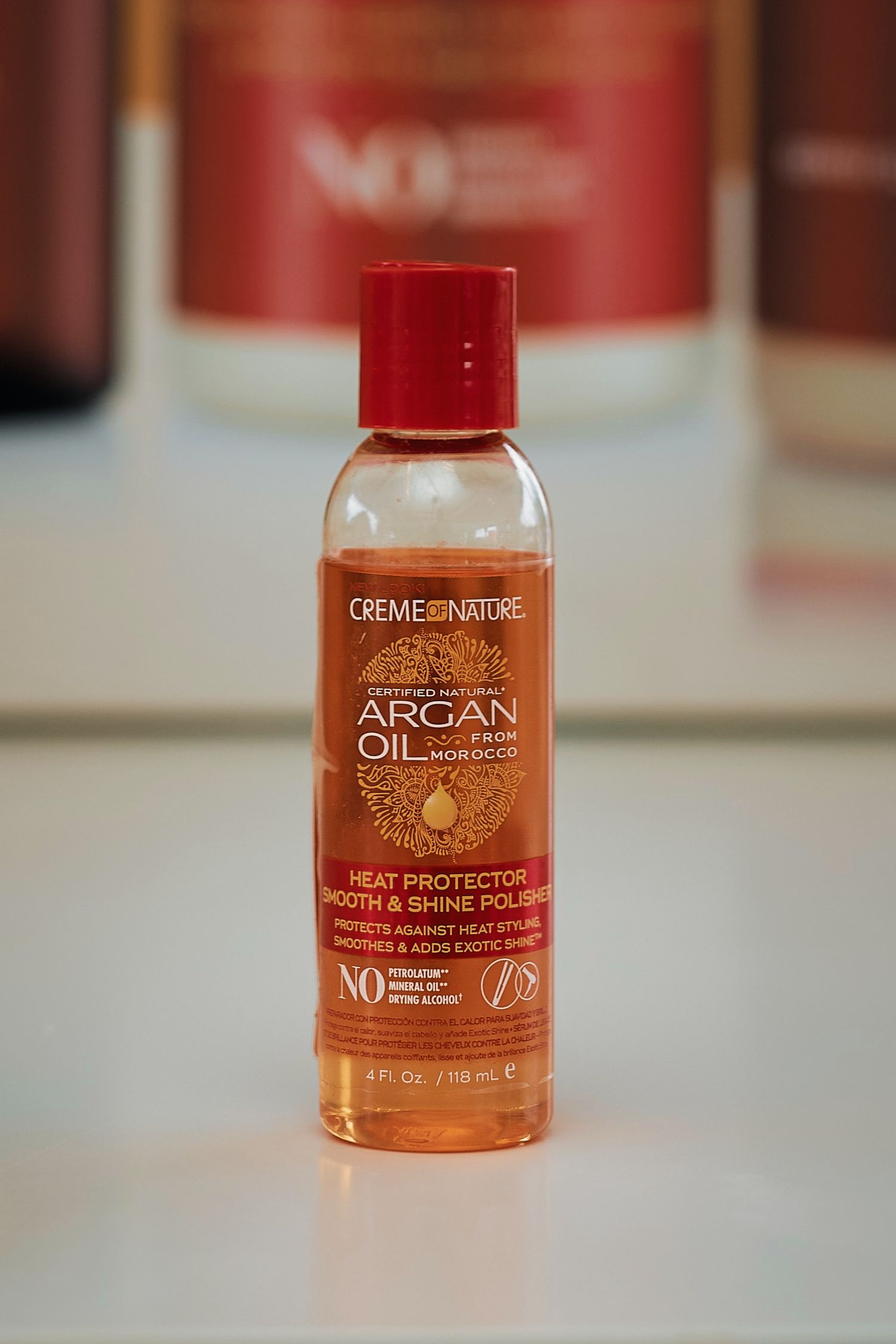 Creme of Nature Argan Oil Heat Protector Smooth and Shine Polisher 4oz bottle on display.