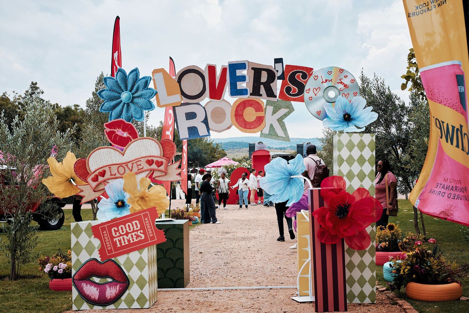 Colorful Lover's Rock festival entrance arch with retro floral decorations and festive signage.