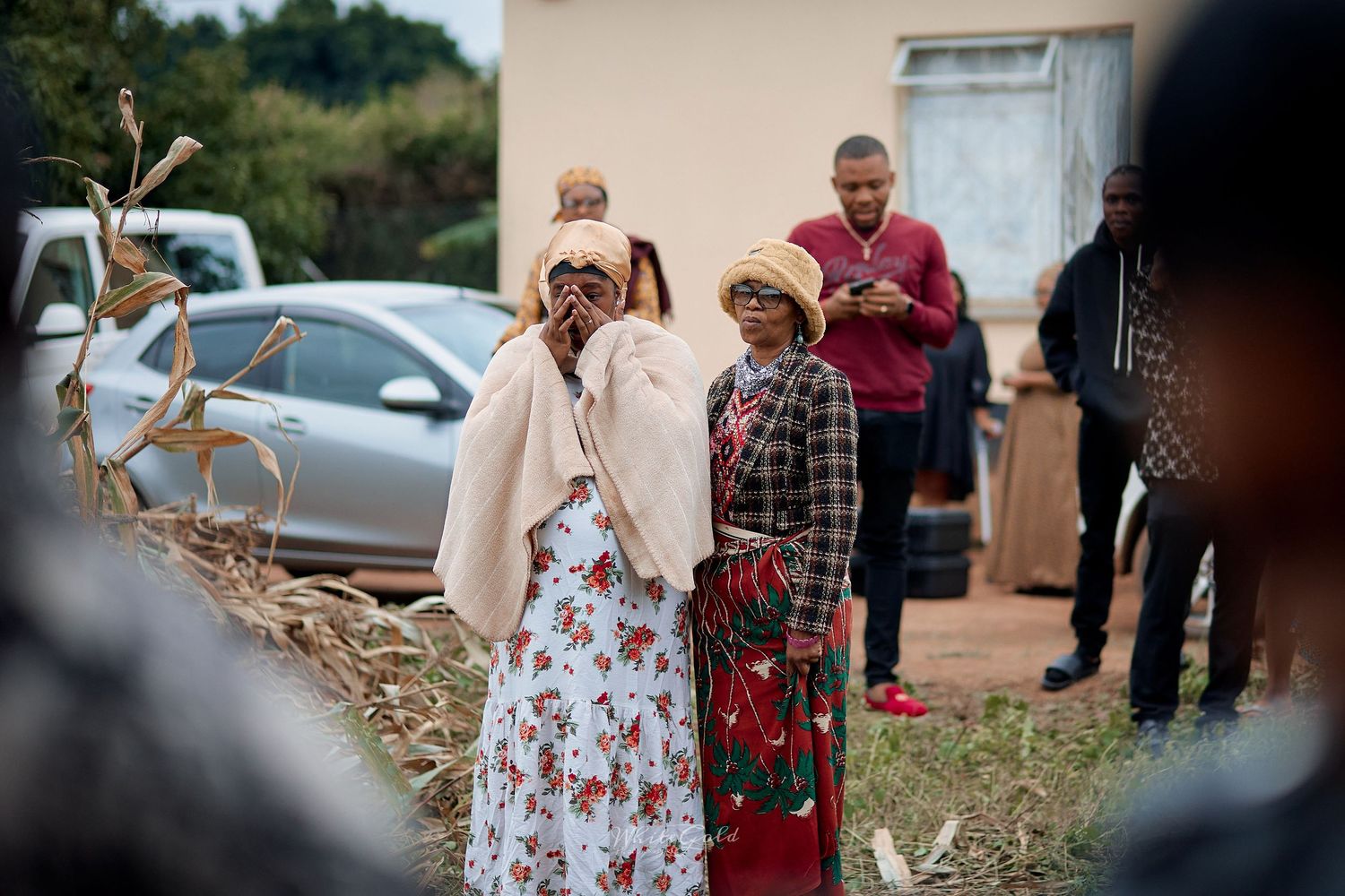 Women in traditional African attire gather outdoors at a rural cultural event.