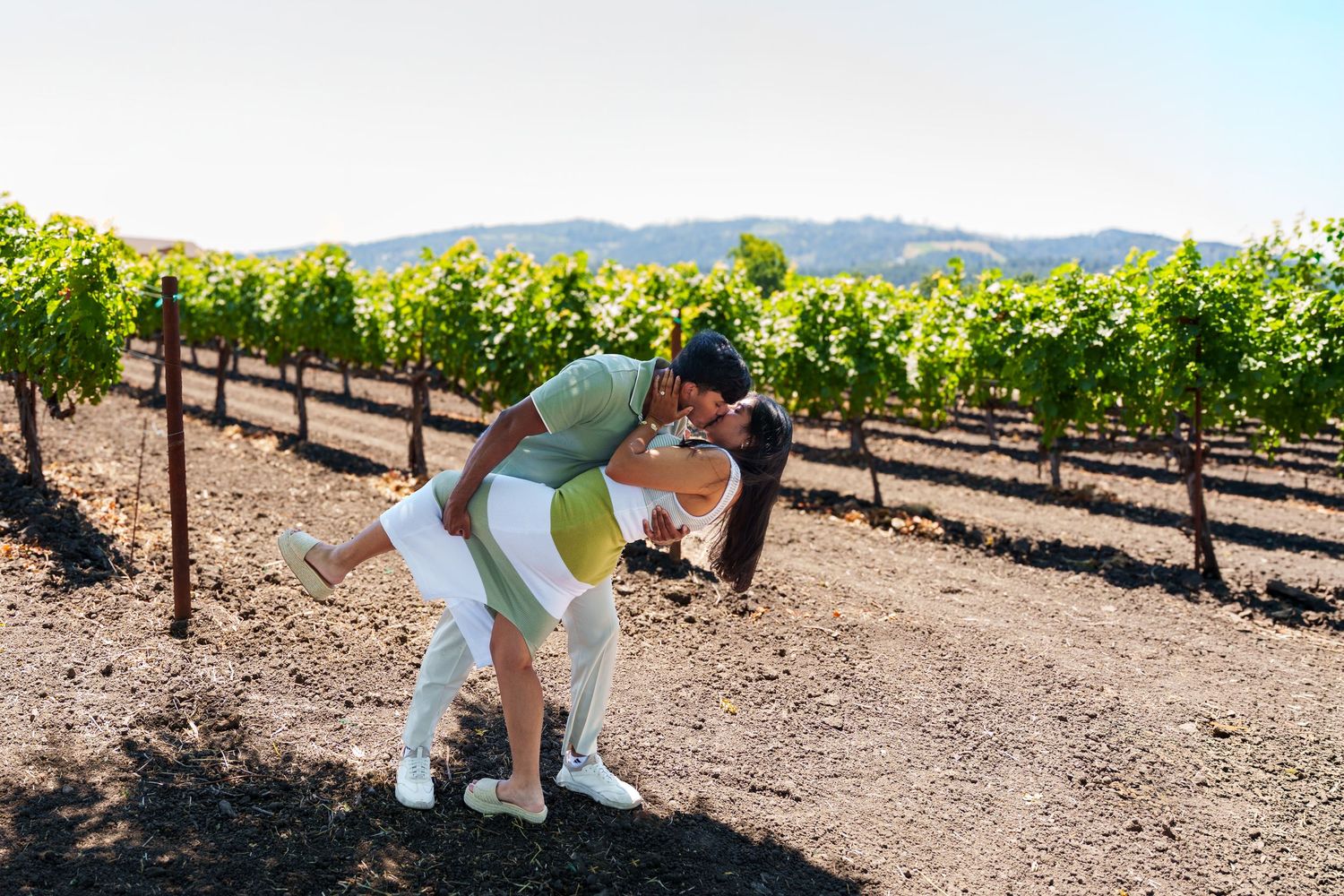 A young couple kissing during their engagement photography session at Maria Concetto winery in Calistoga Napa Valley.