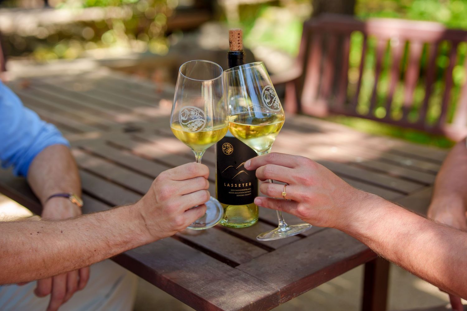 A male couple toasting with sauvignon blanc during their proposal photography session at Lasseter family winery in Glen Ellen, Sonoma.