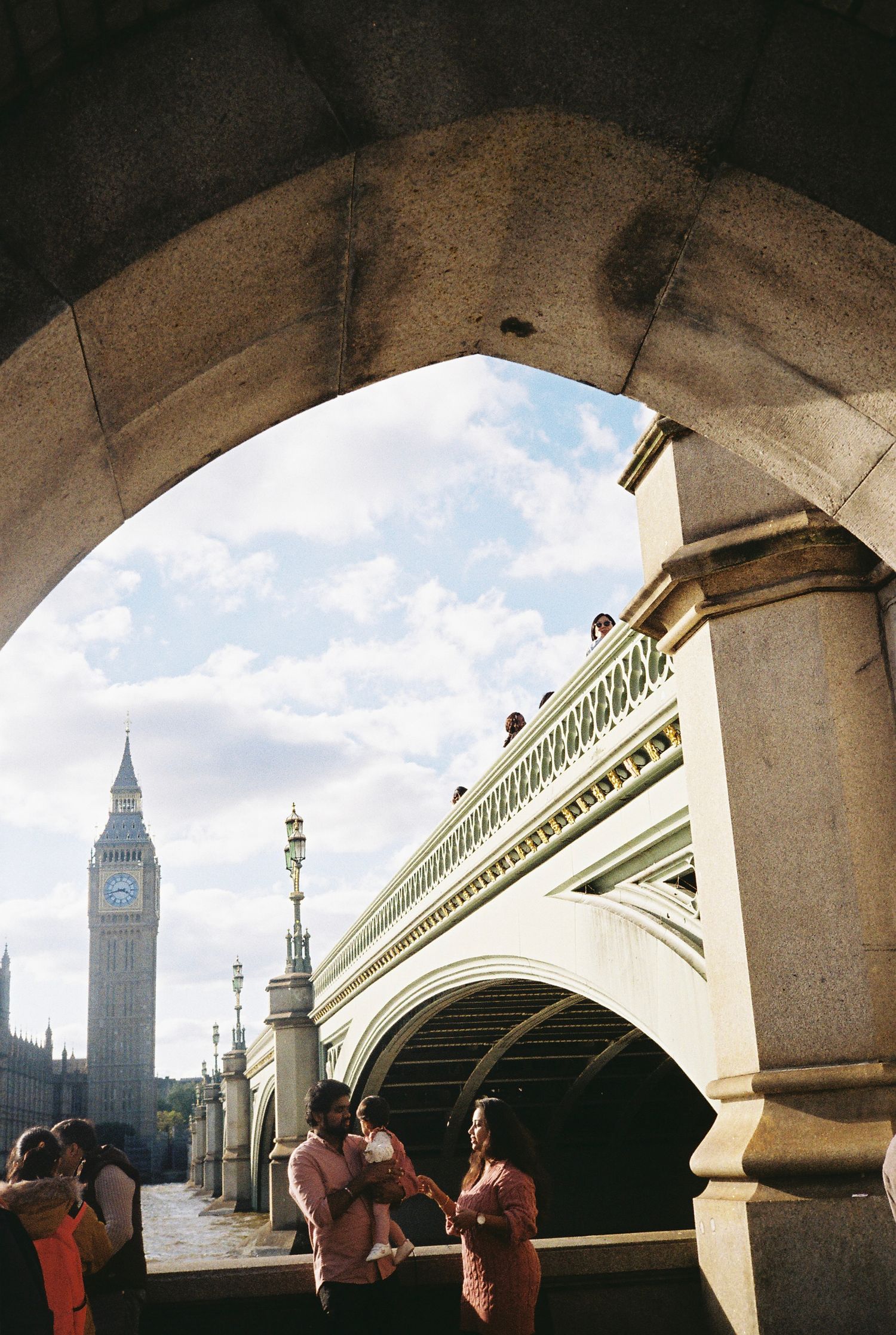 View of Big Ben and Westminster Bridge through a stone archway in London, England.