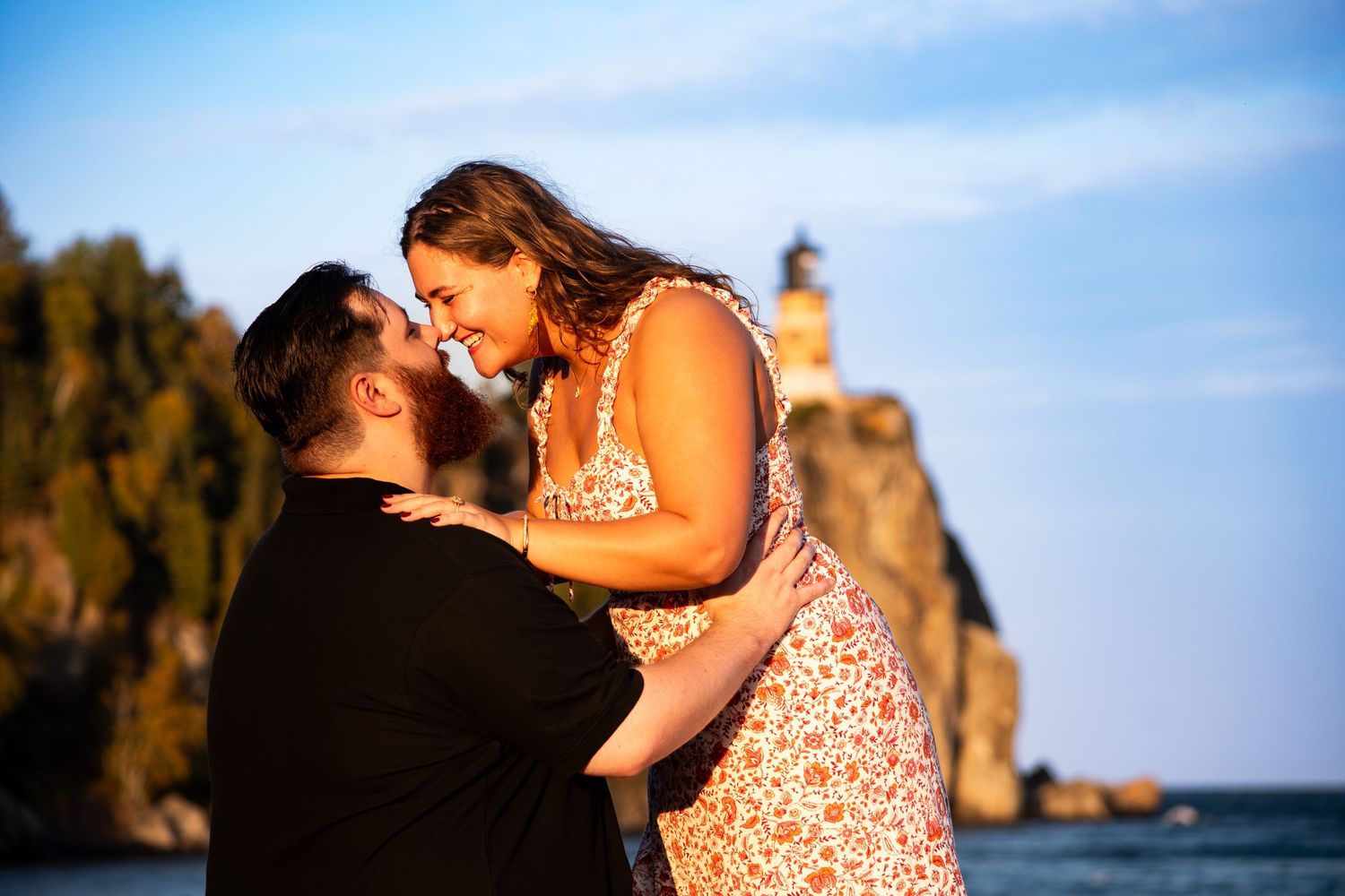 Couple sharing a romantic moment at sunset near Split Rock Lighthouse on Lake Superior, Minnesota.