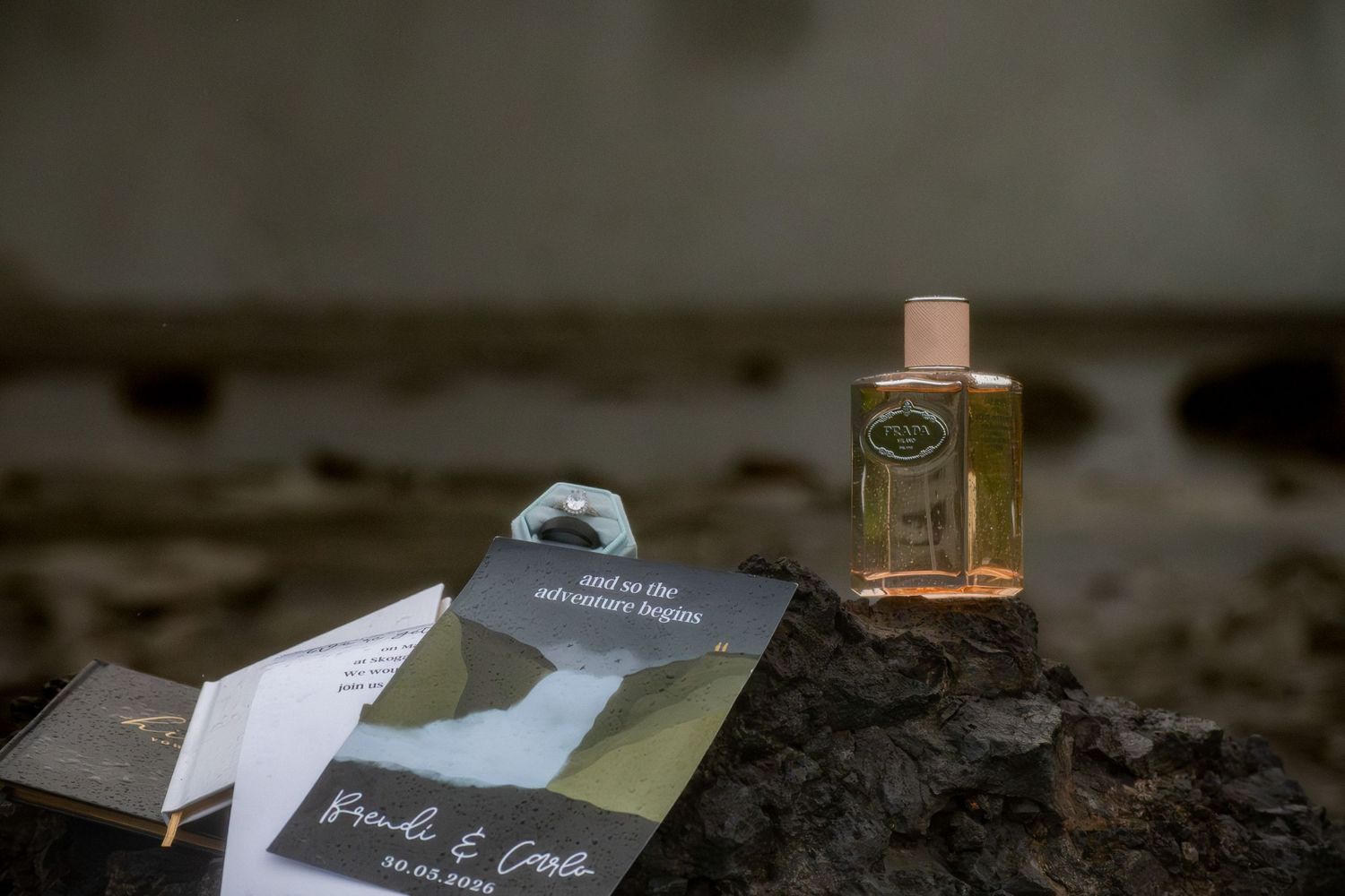 Wedding stationery and perfume bottle displayed on rustic stone surface for elegant bridal flat lay.