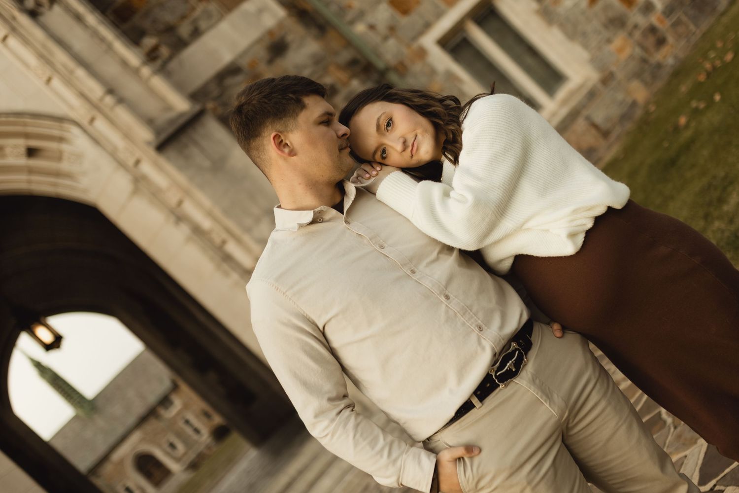 A romantic couple shares tender moments in elegant wedding attire against architectural backdrops.