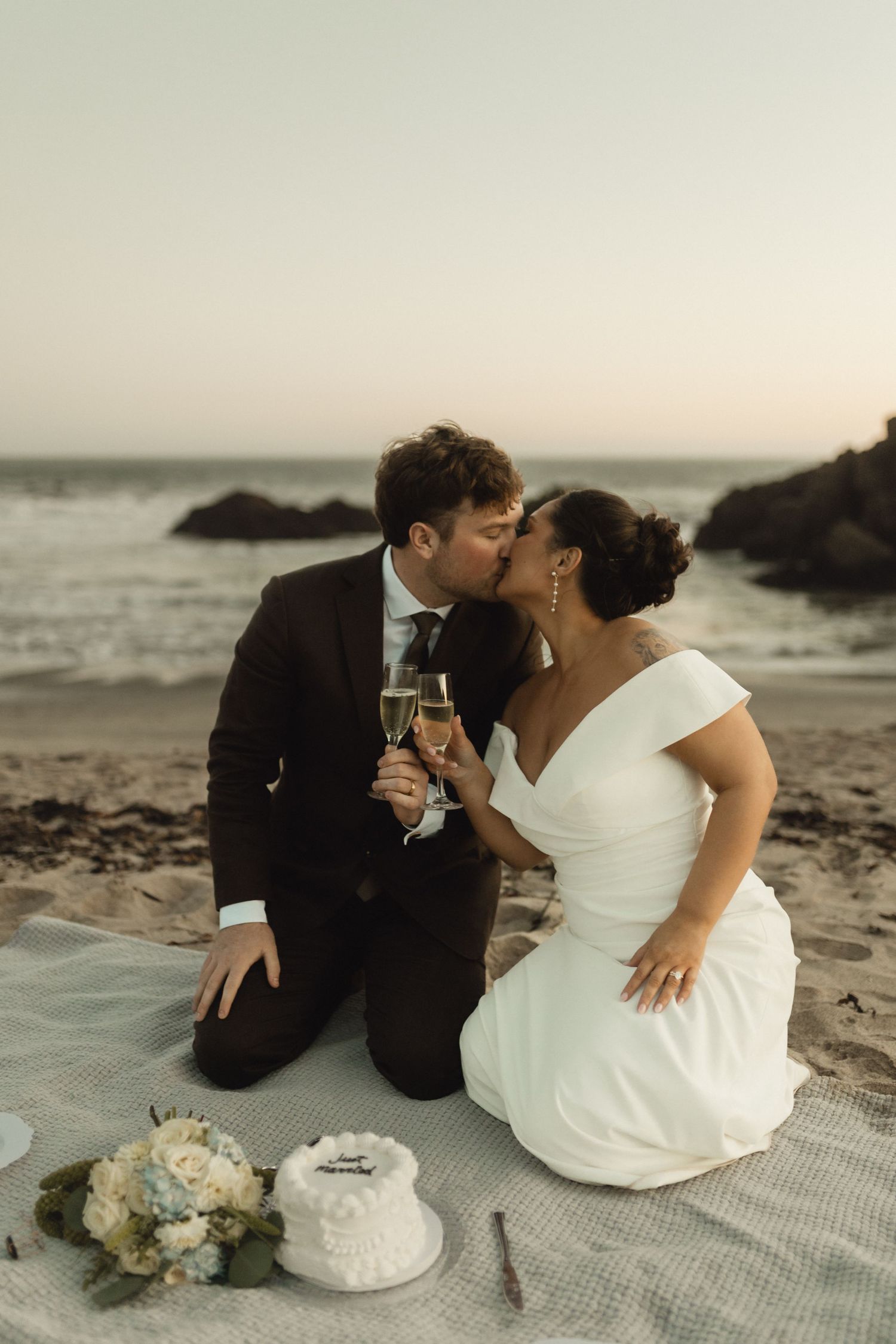 A romantic beach picnic celebration with champagne at sunset.