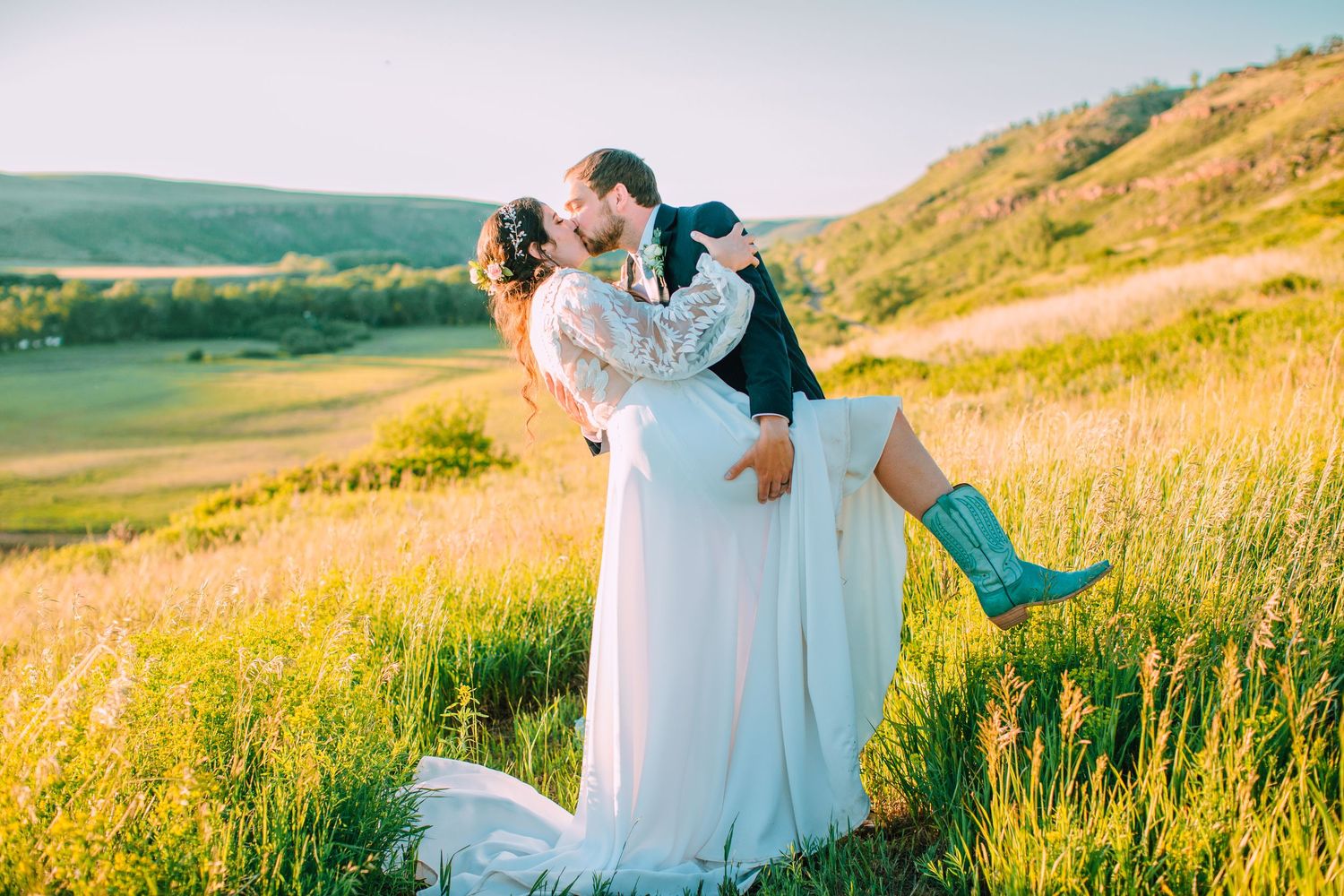 A couple embraces in a golden sunlit meadow during a romantic sunset photo session.