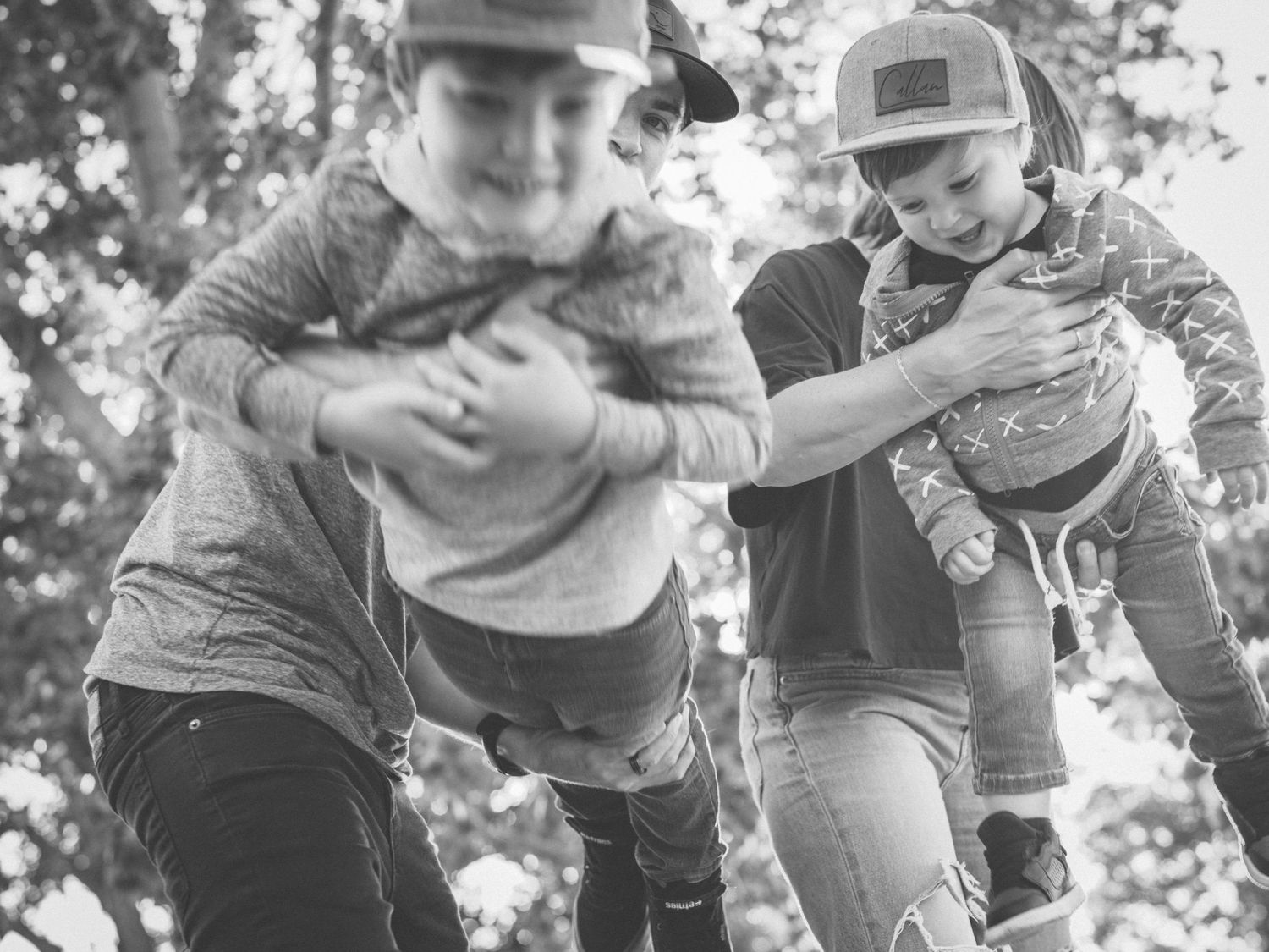 A black and white sequence of photos showing a child and adult playing together outdoors.