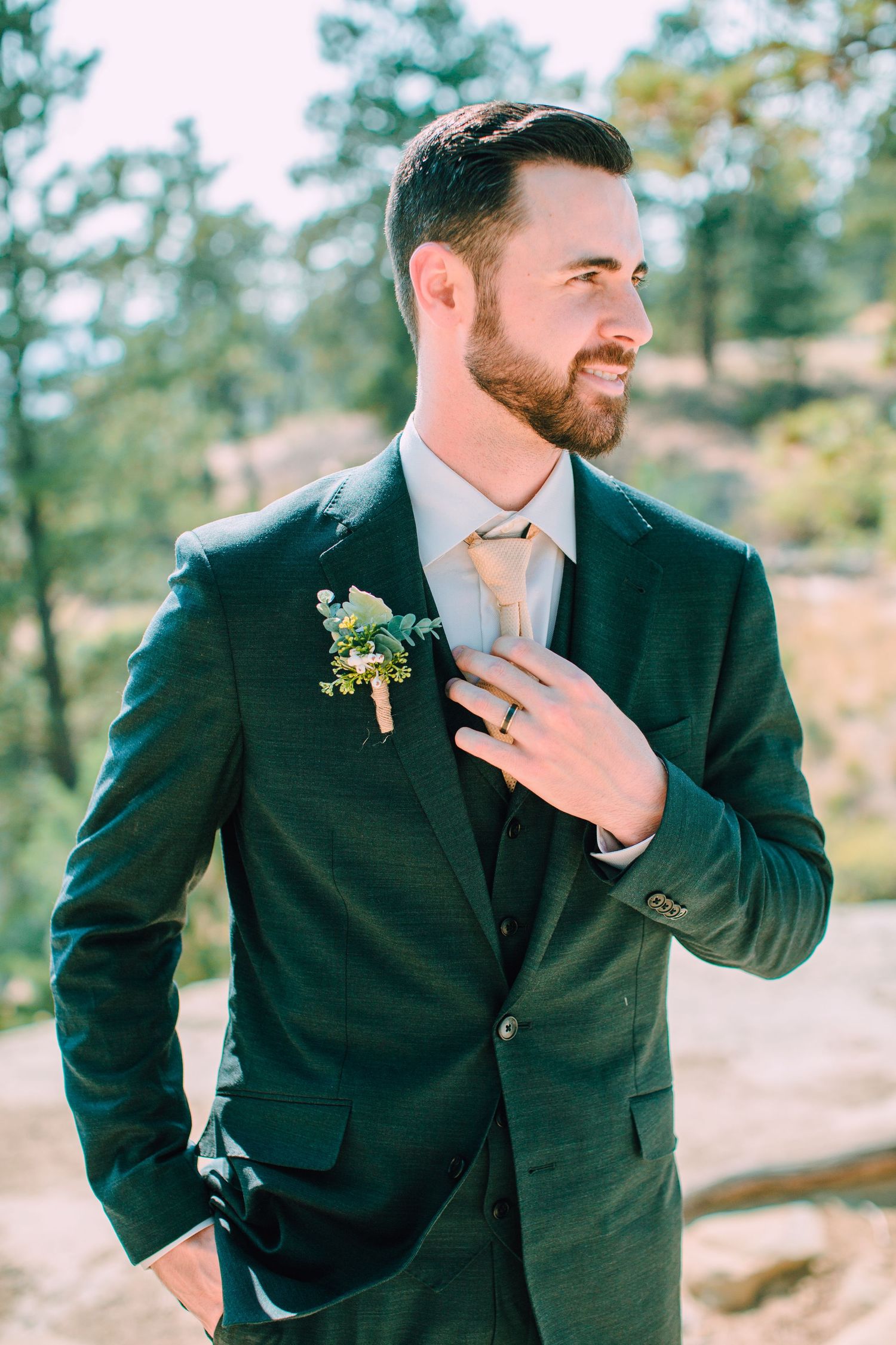 A groom in a dark suit poses candidly outdoors against a natural mountain backdrop in a series of four photos.