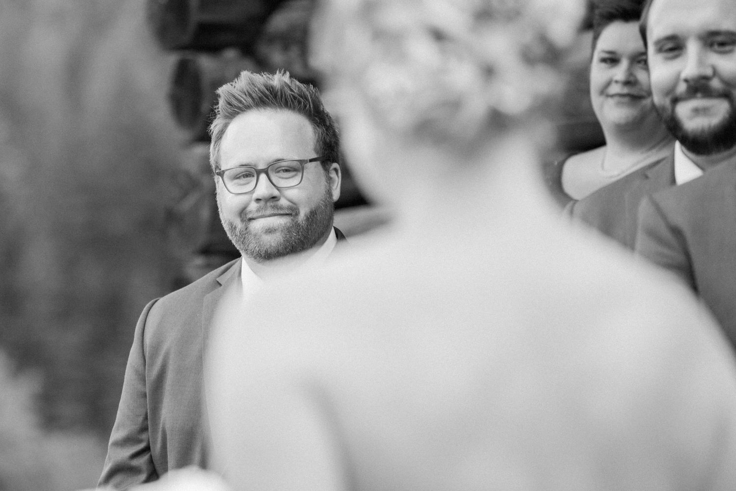 Guest watches emotional wedding ceremony through soft focus lens.