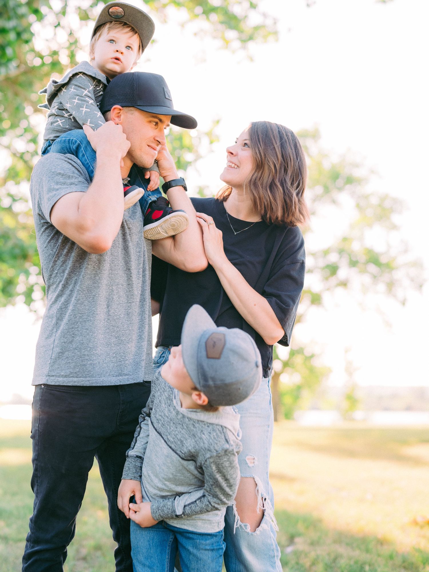 A happy family enjoying a playful moment together outdoors on a sunny day.