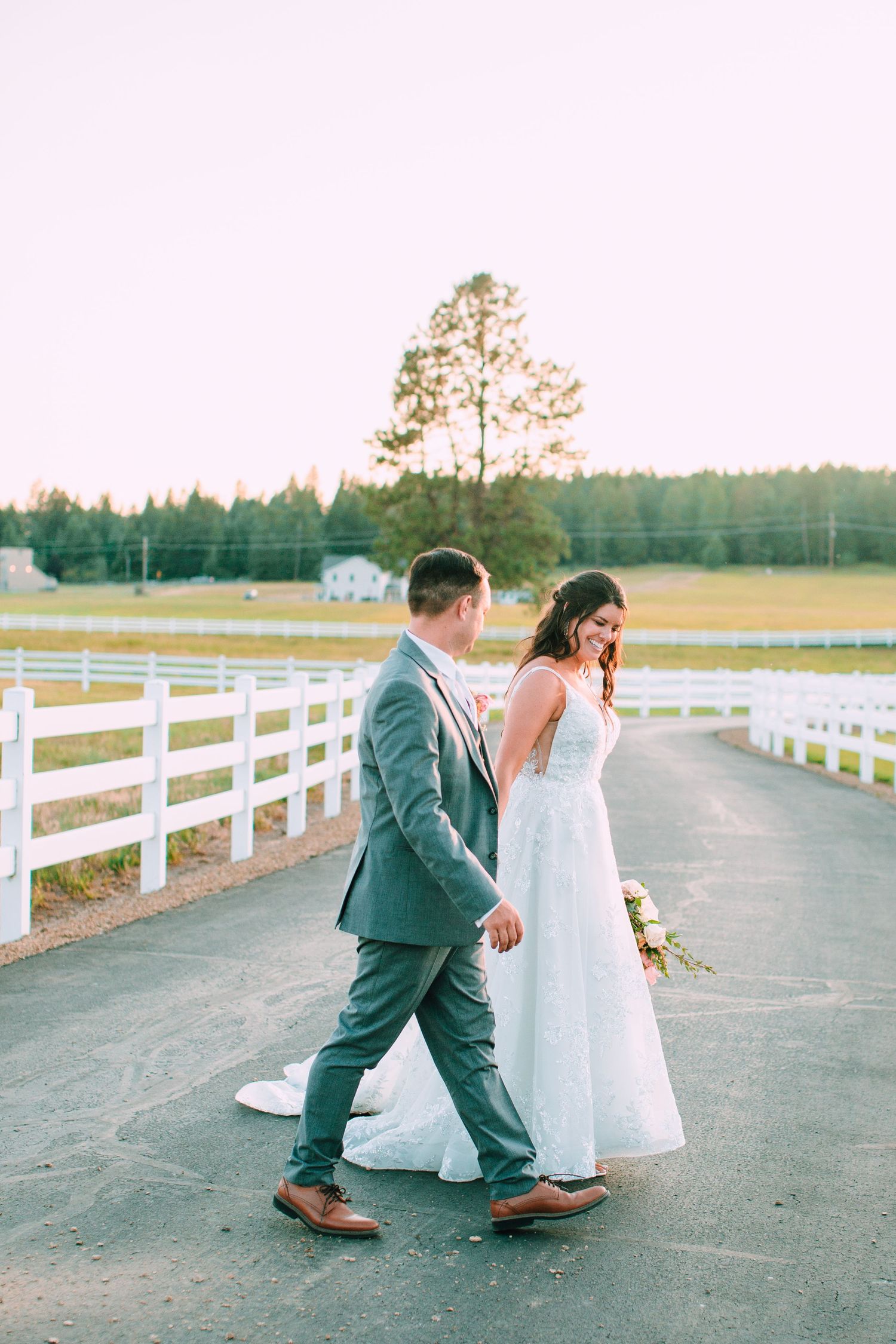 Three sequential photos of a couple dancing playfully on a country road lined with white fences at sunset.