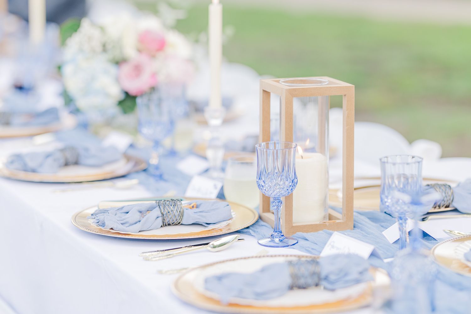 Elegant table setting with soft blue and white decor and delicate glassware.