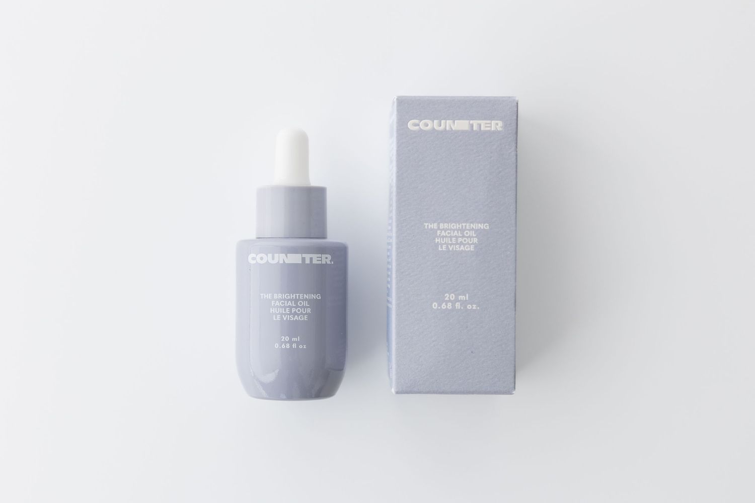 Gray skincare product bottle and packaging on white background.