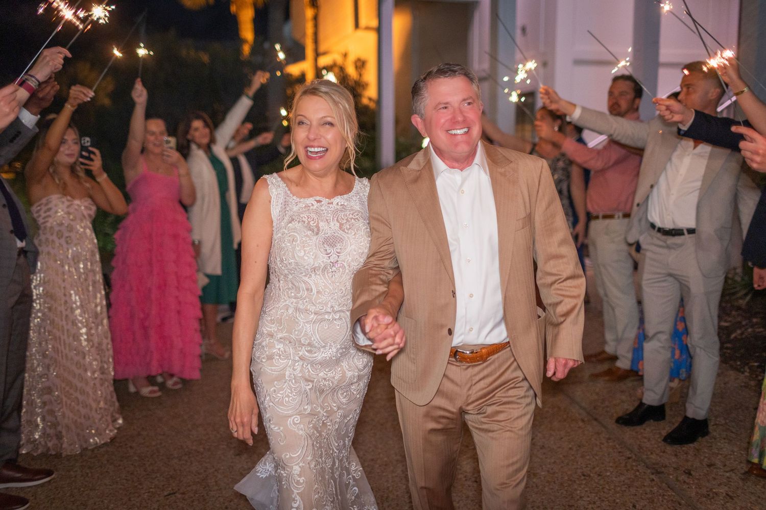 Wedding reception guests dancing under warm evening lighting  landfall wedding bride groom light and airy classic wilmington Wrightsville