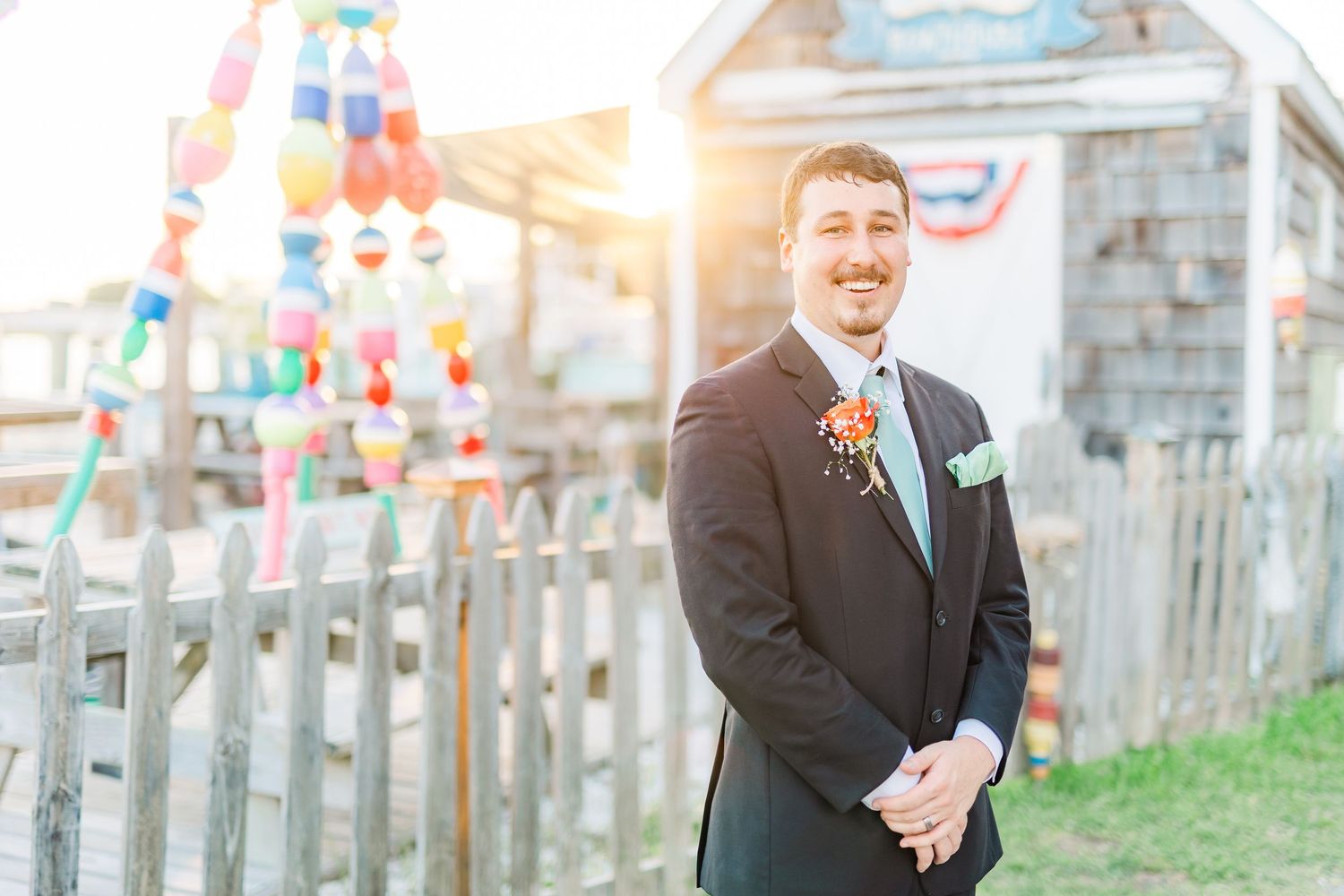 Wedding party poses outdoors against wooden fence southport elopement wedding bride groom light and airy classic