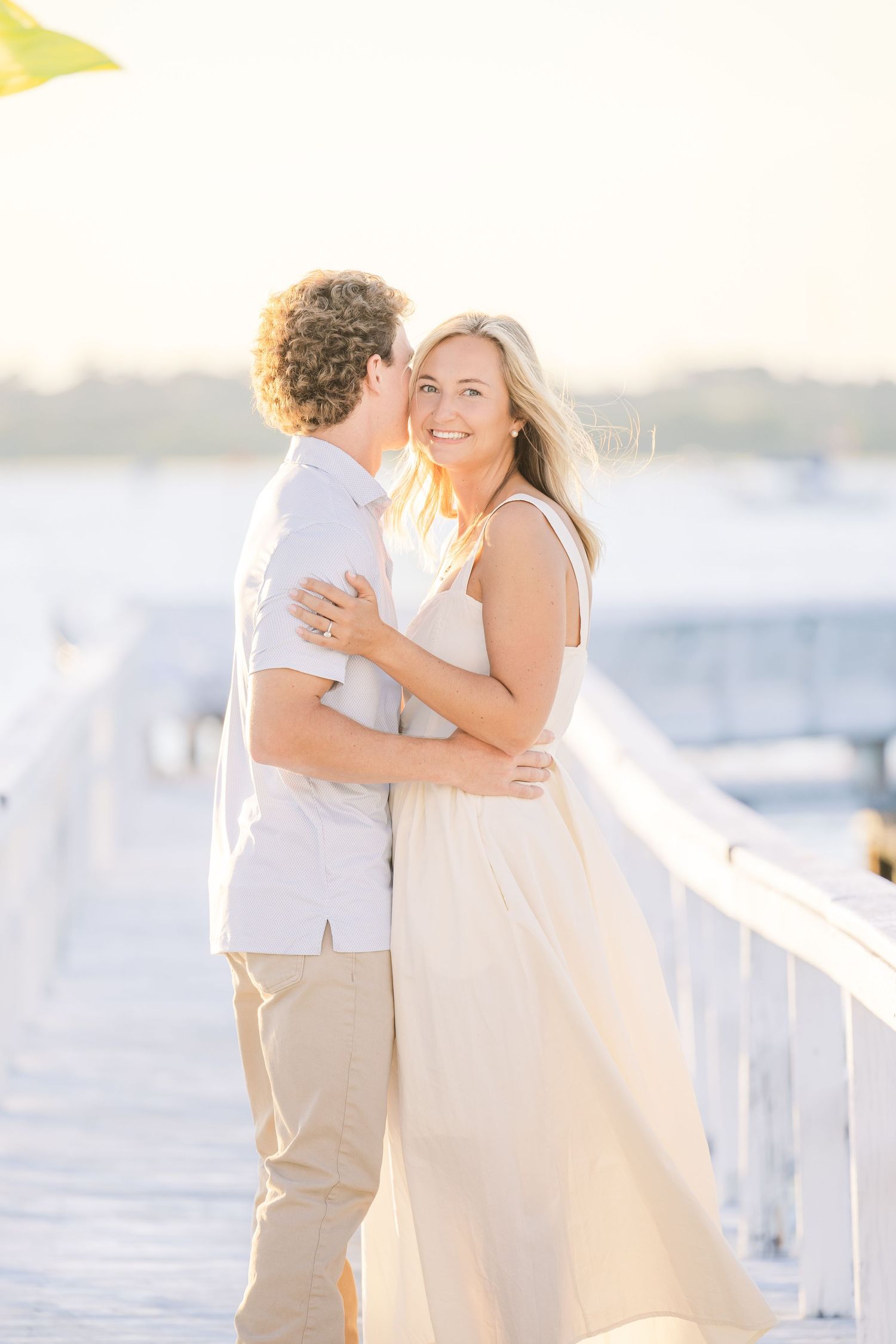 A tender embrace captured in golden sunlight on a marina dock.