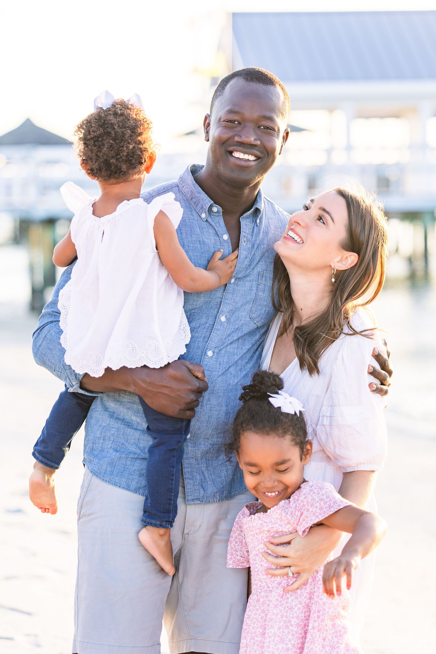 Family sharing intimate moments and laughter during a beach photoshoot.