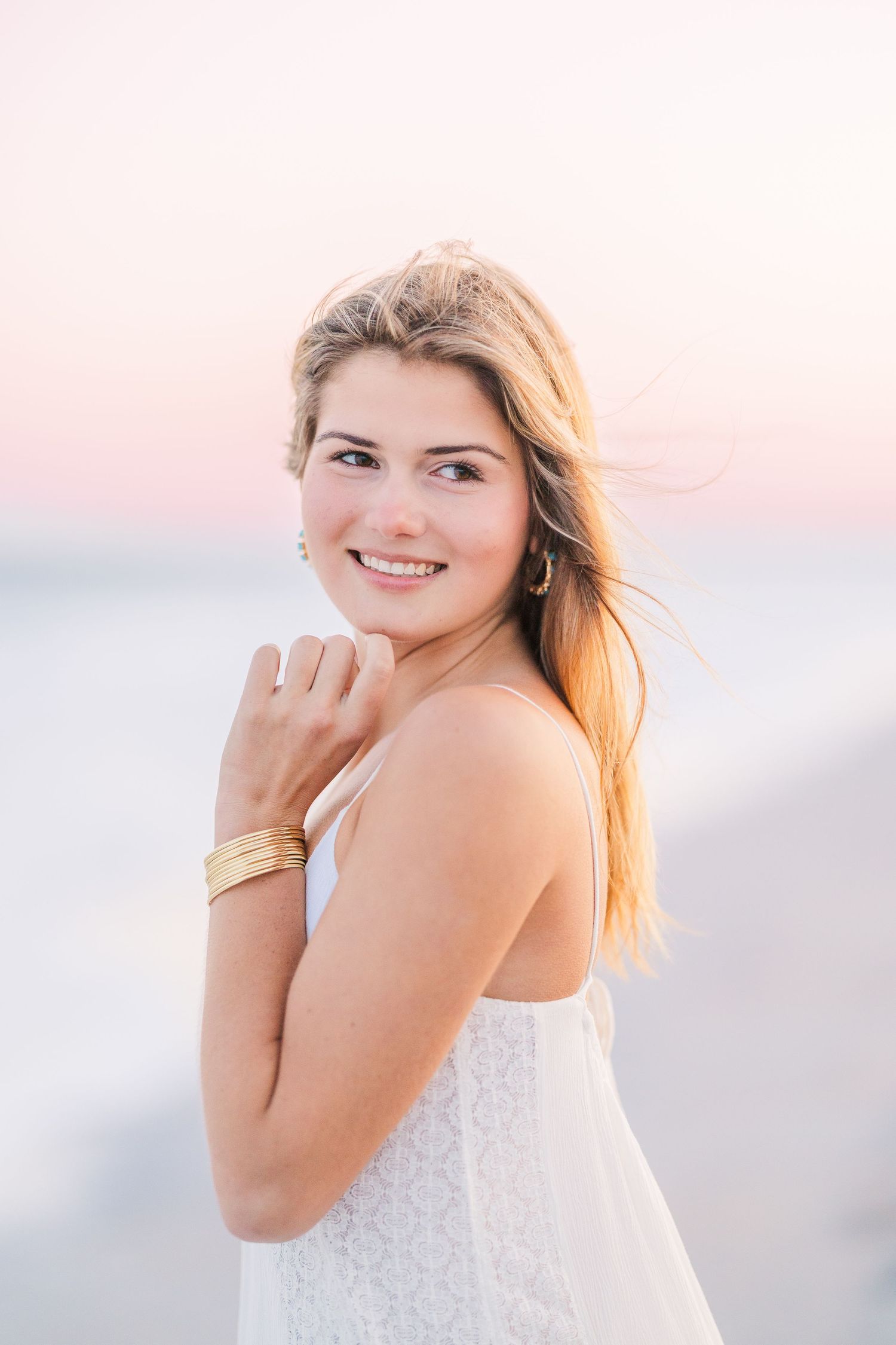 Artistic beach portraits with golden light and white lace details.