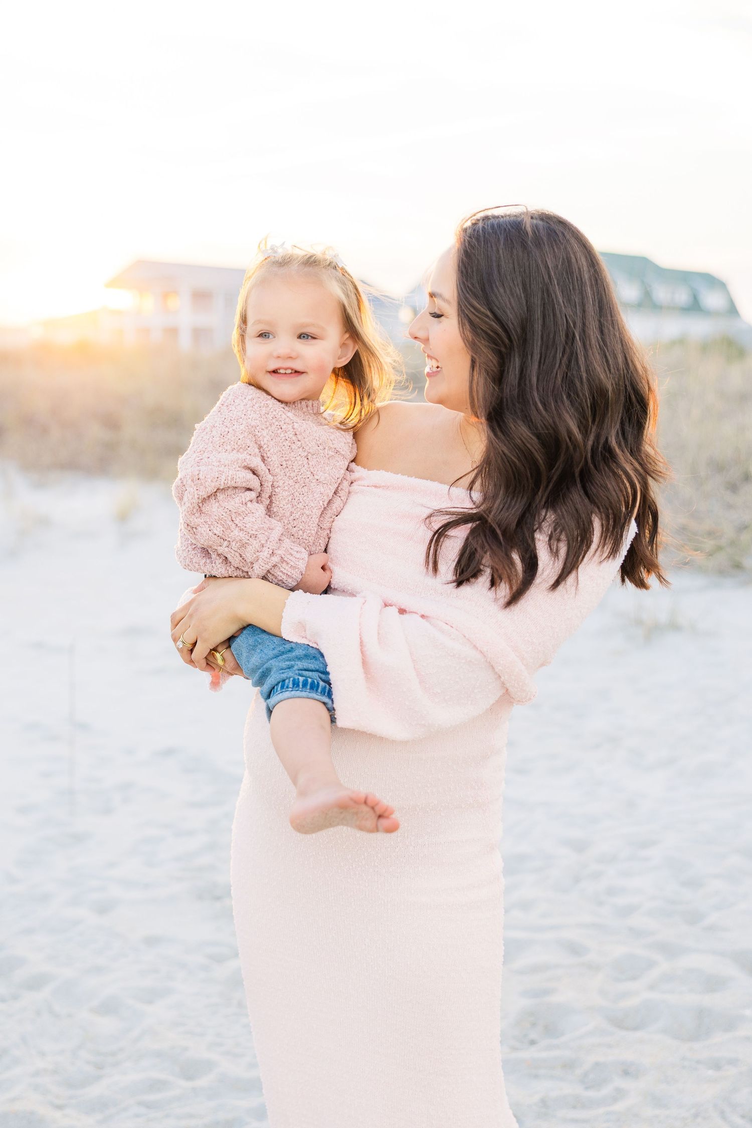 Intimate family portraits on beach with coordinated pink and denim outfits.