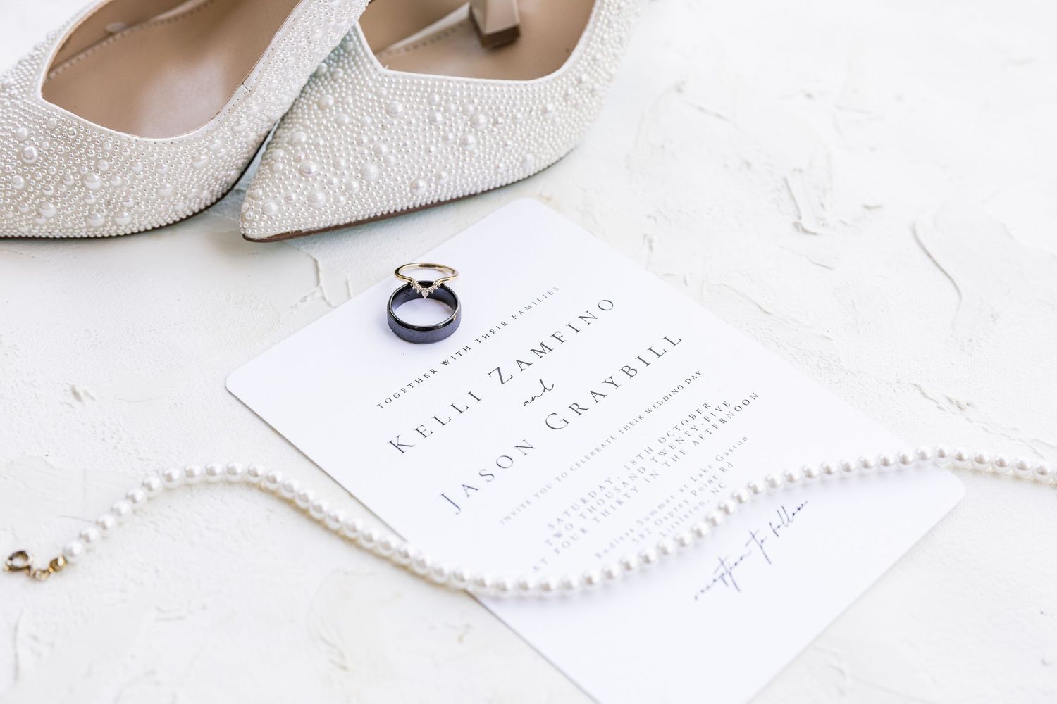 Elegant white bridal shoes and wedding stationery arranged on a light marble surface wedding groom bride lake Gaston photographer light airy