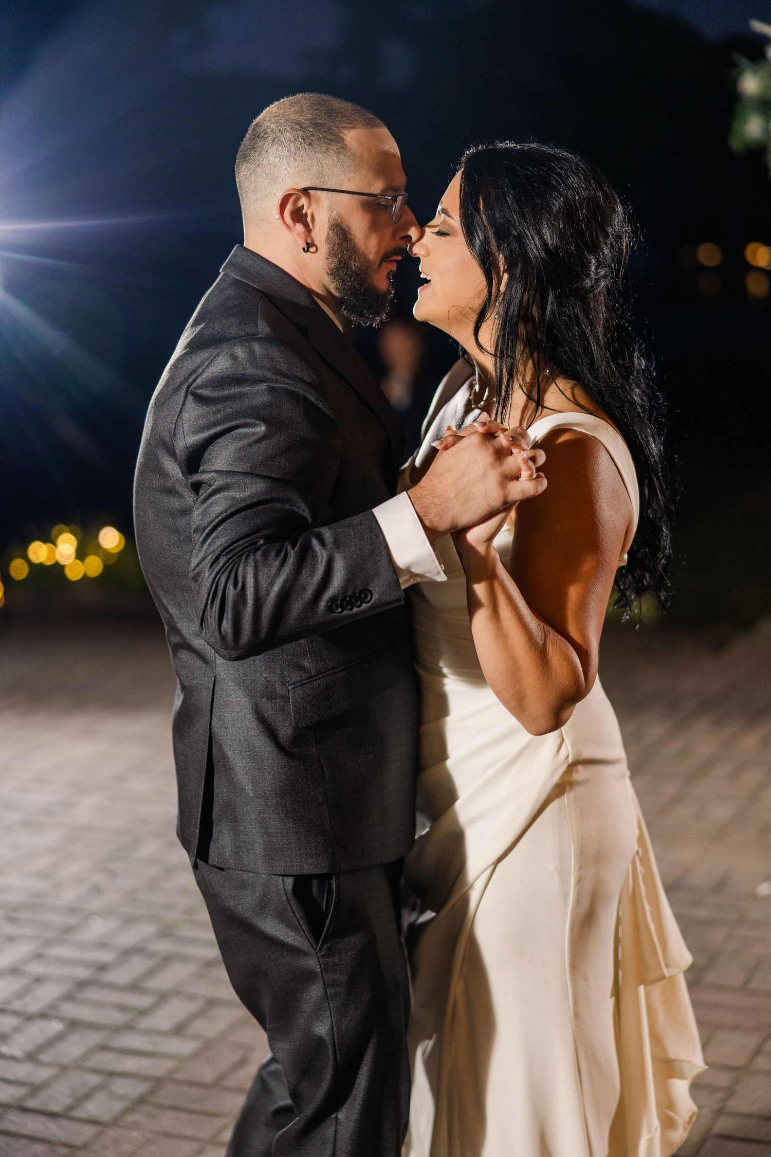 Romantic nighttime dance between newlyweds under outdoor lighting wedding groom bride lake Gaston photographer light airy