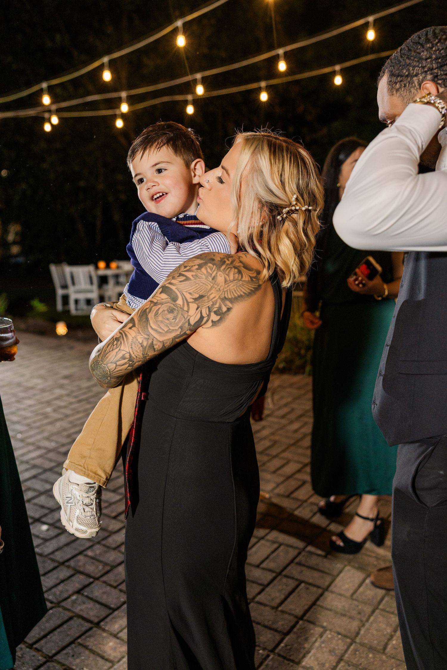 Guests dancing and embracing at nighttime outdoor wedding celebration wedding groom bride lake Gaston photographer light airy