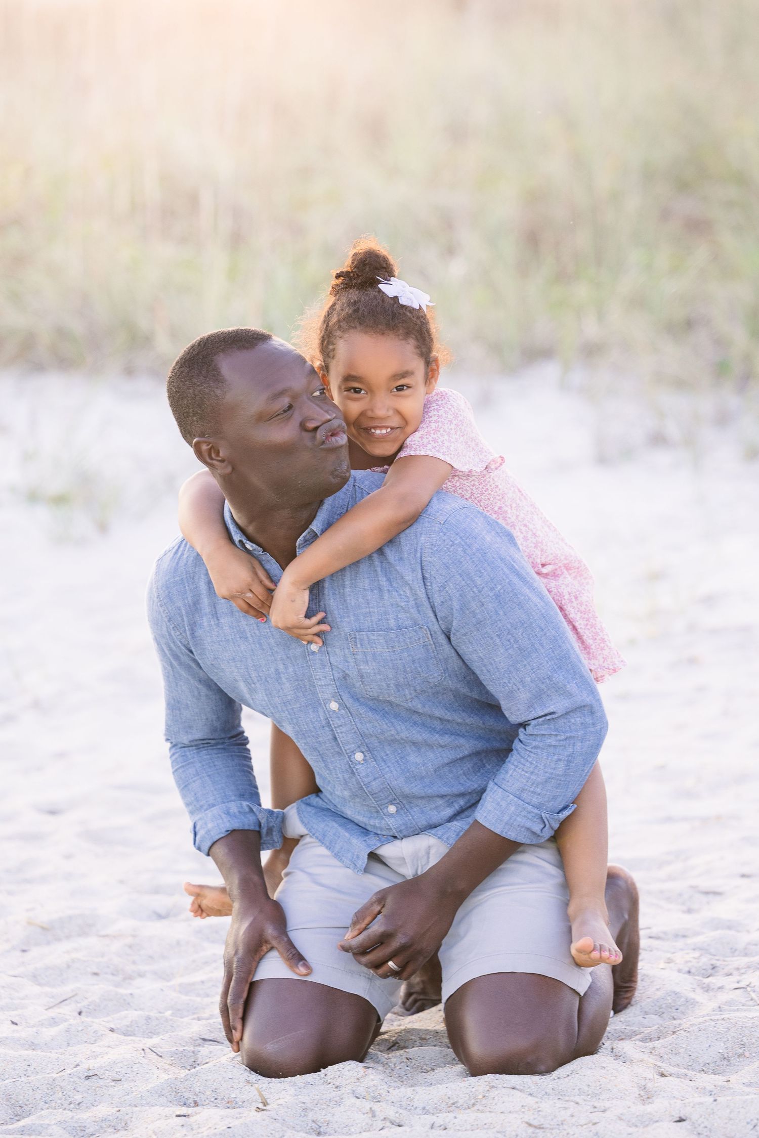 Sweet candid moment of father and daughter hugging on the beach.