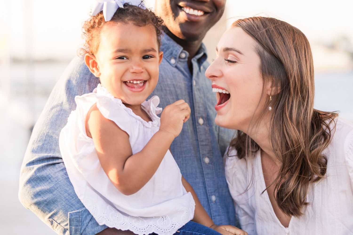 Happy family sharing laughs and embraces on a bright sunny day.
