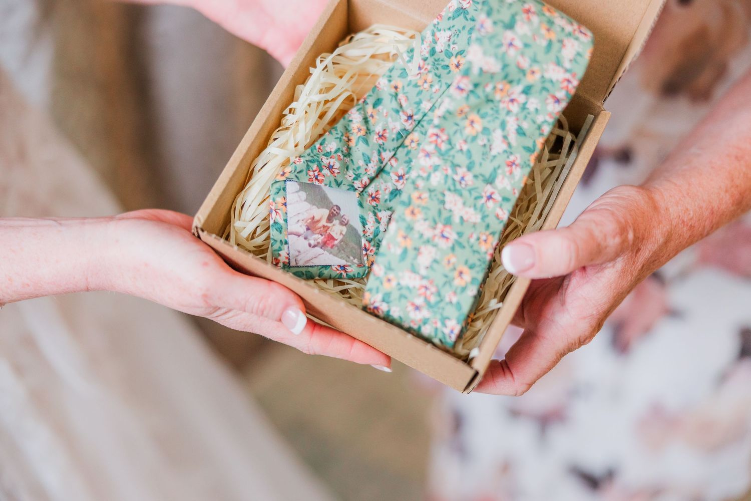 Hands holding a decorative box with floral patterned paper inside from a wilmington, nc wedding