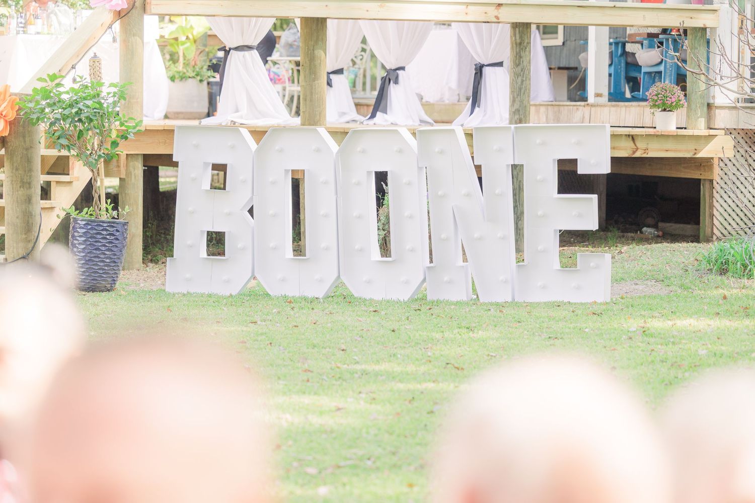 Decorative white letters spell out 'Just Married' hanging on rustic outdoor display.