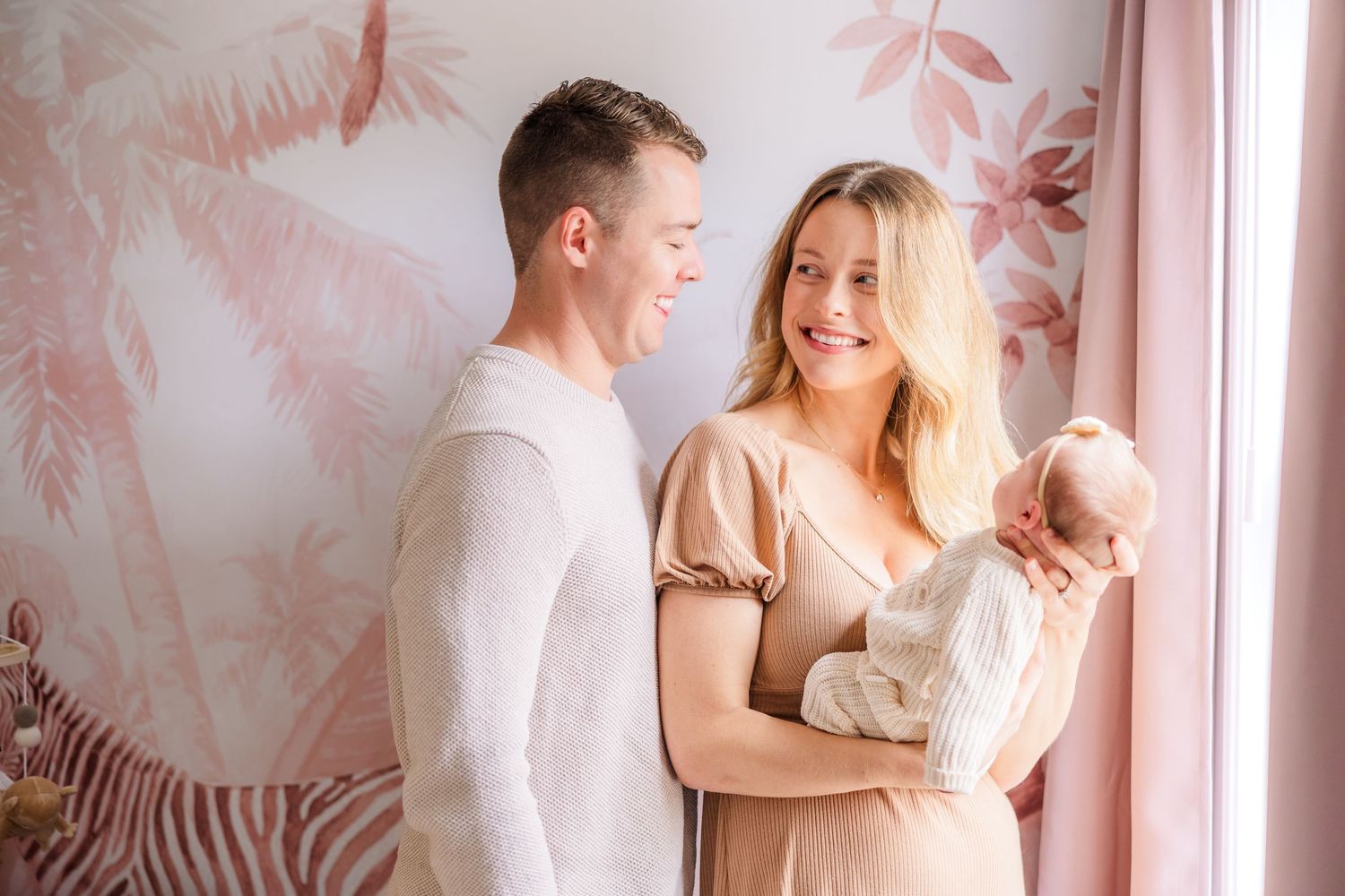 Intimate family portrait session with soft pink tones and gentle embraces.
